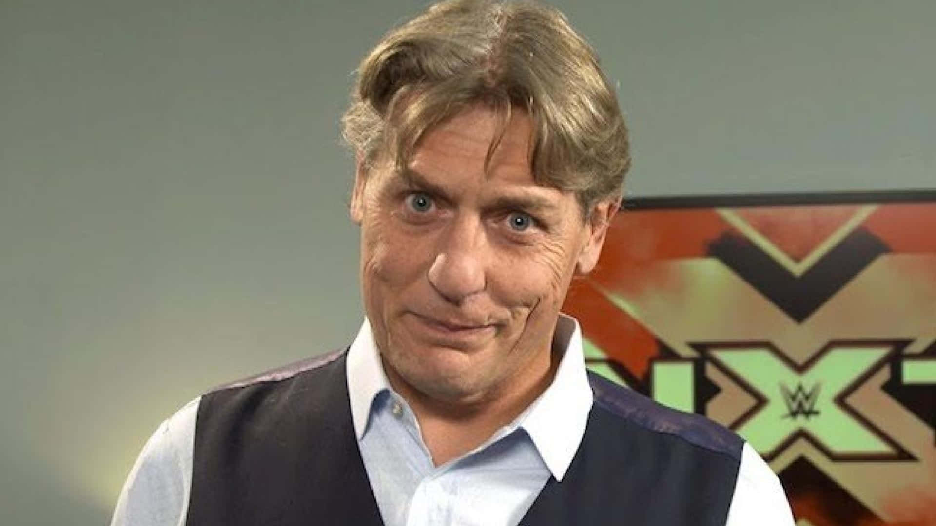 摔角 桌布 壁紙 — 一位頭髮花白、藍眼睛深邃的男子，穿著背心在襯衫外面，微微一笑。