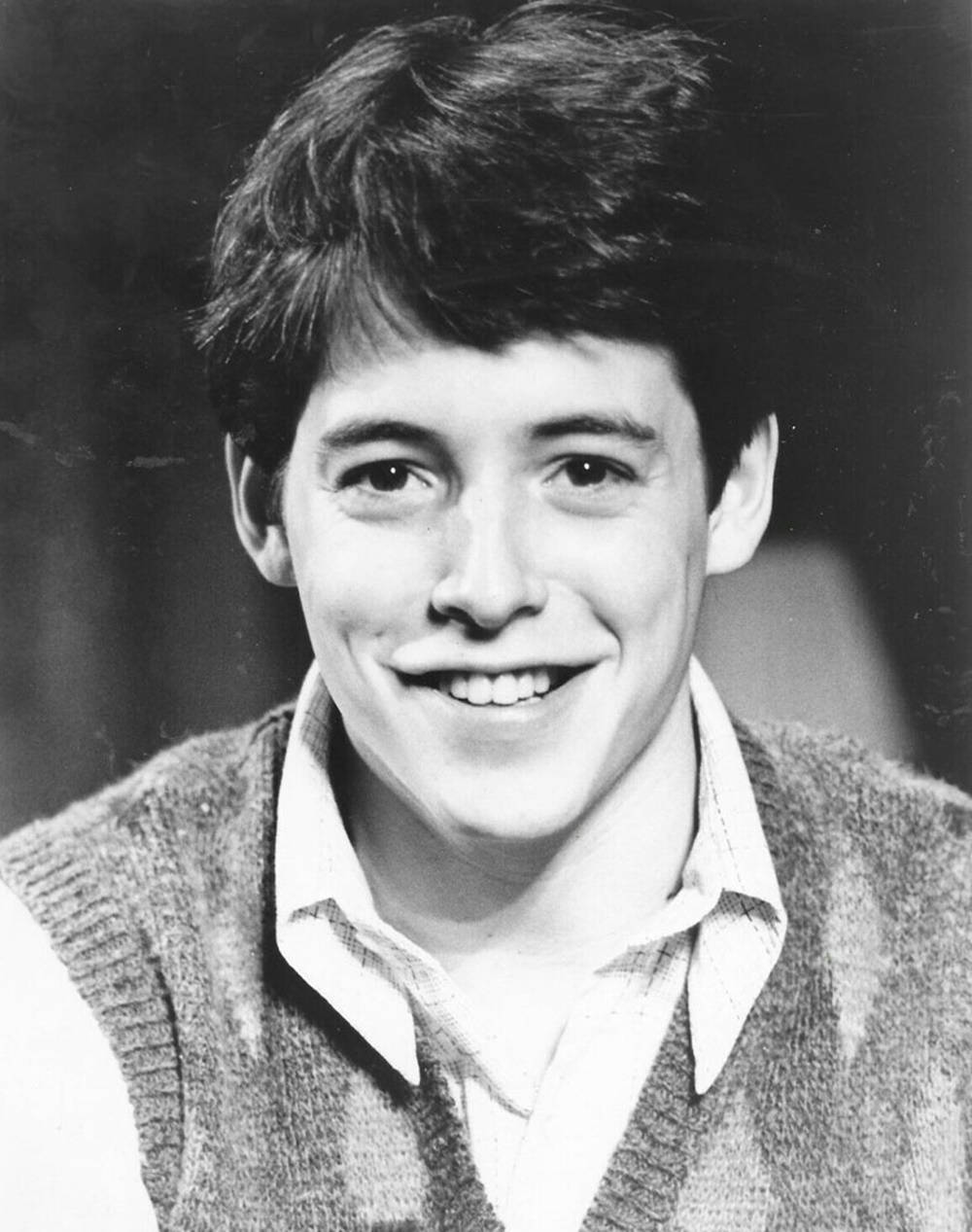 actor 桌布 壁紙 — 一位頭髮蓬鬆的年輕男子穿著針織背心內搭有領襯衫，在黑白肖像中溫暖地微笑。