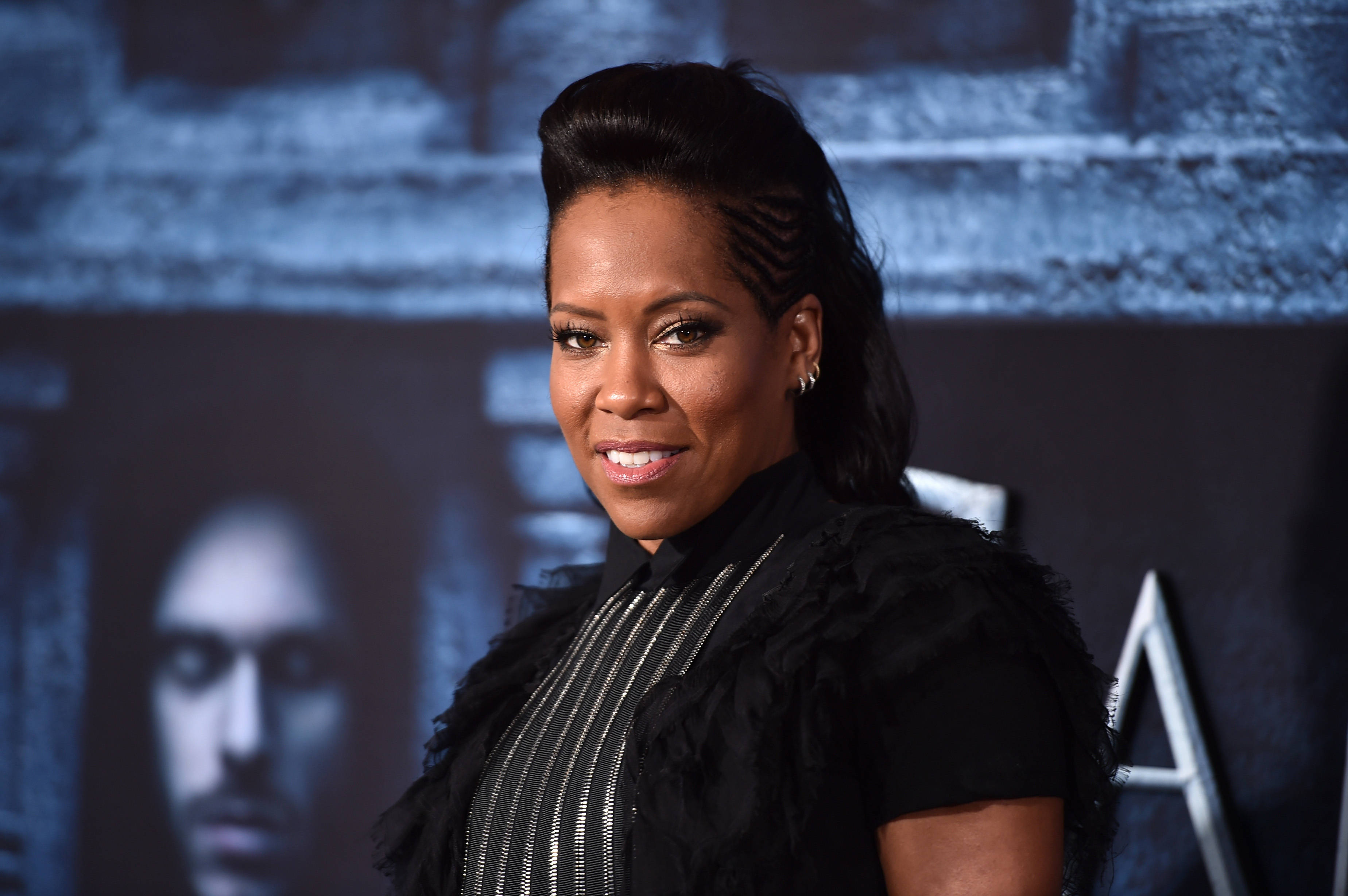 Celebrity 桌布 壁紙 — 一位頭髮造型、身穿黑色羽毛上衣的女性，在深藍色紋理背景前對著鏡頭微笑。