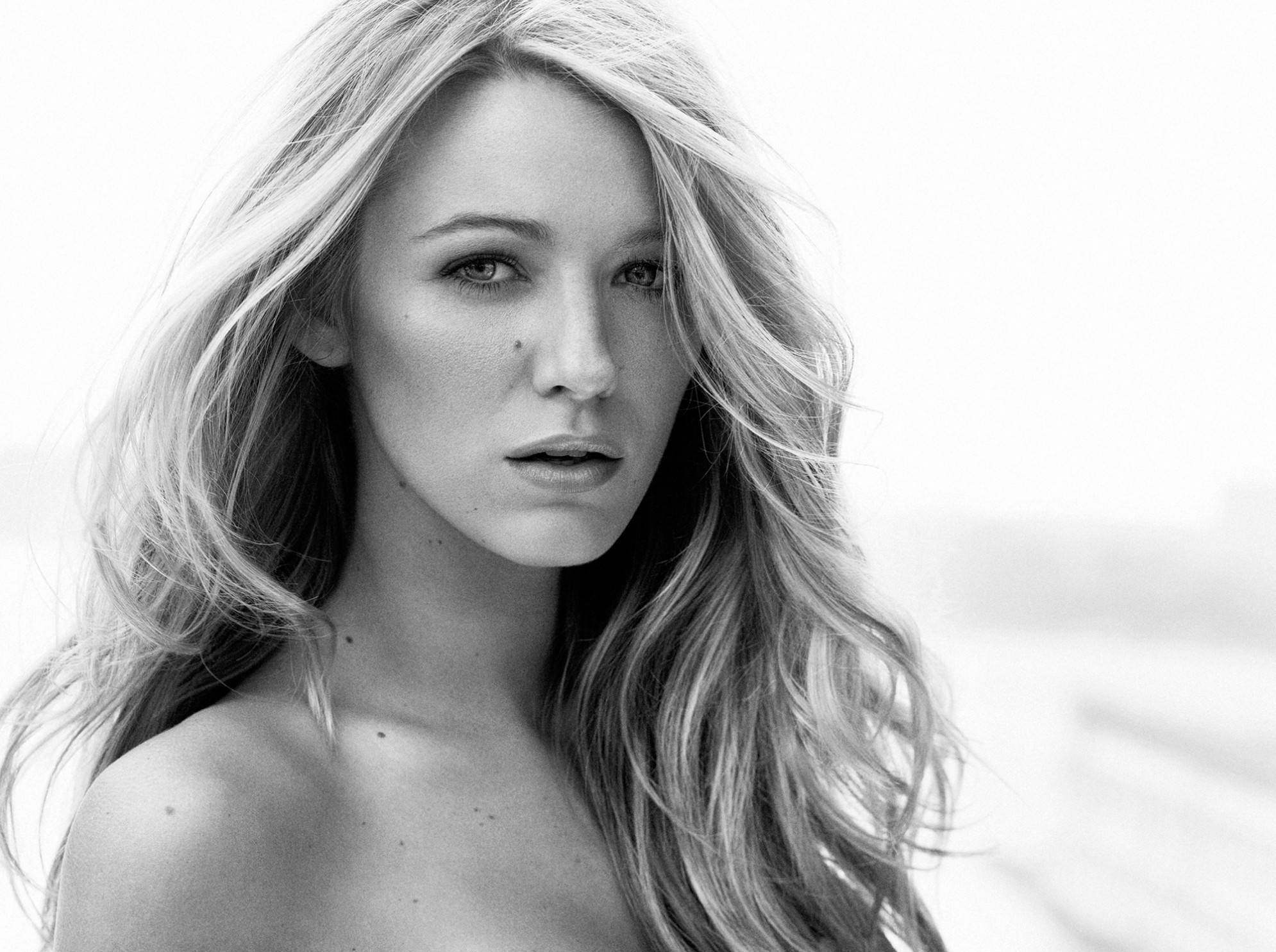 Blake 桌布 壁紙 — 一位頭髮隨風飄揚的女性黑白肖像，她以柔和的表情直視鏡頭。