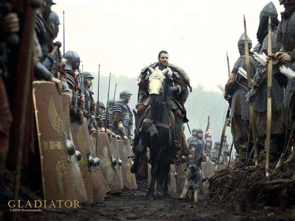 Gladiator 桌布 壁紙 — 一位騎馬的羅馬將軍在泥濘的戰場上指揮他的部隊，兩側是手持盾牌和長矛的士兵。