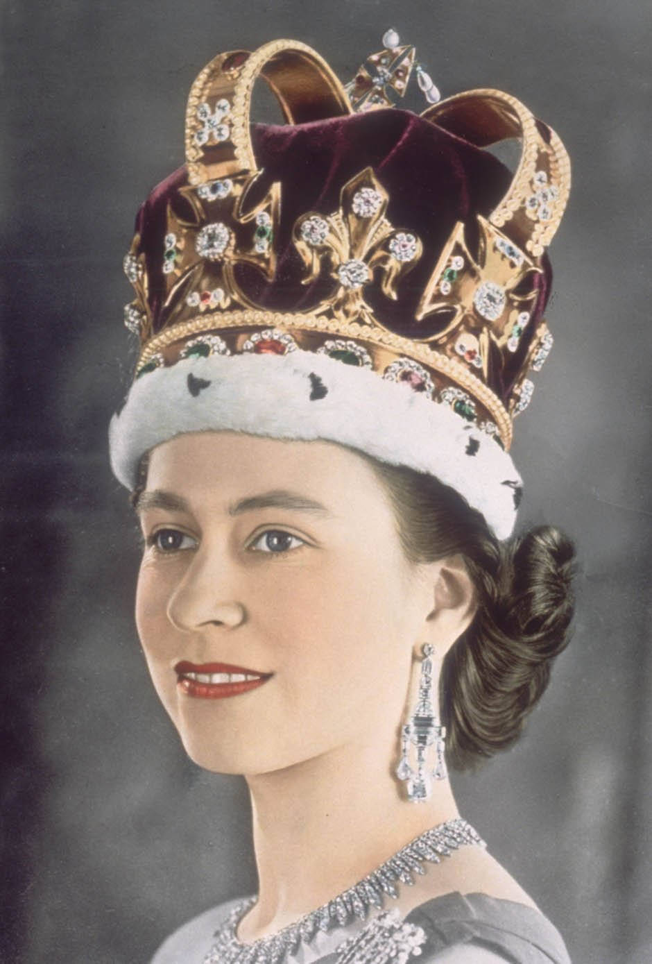 Queen Elizabeth 桌布 壁紙 — 一位高貴的女性戴著鑲有寶石、天鵝絨和鑽石的王冠，背景為深色。