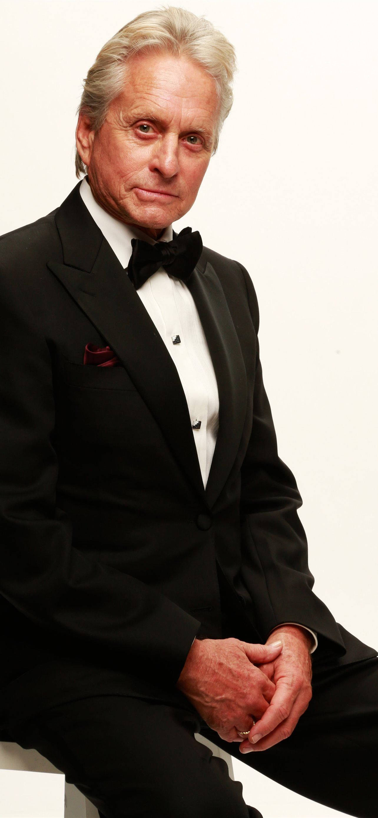 actor 桌布 壁紙 — 一位高貴的年長男士身穿黑色燕尾服，搭配紅色口袋方巾，在純白背景前自信地擺姿勢。