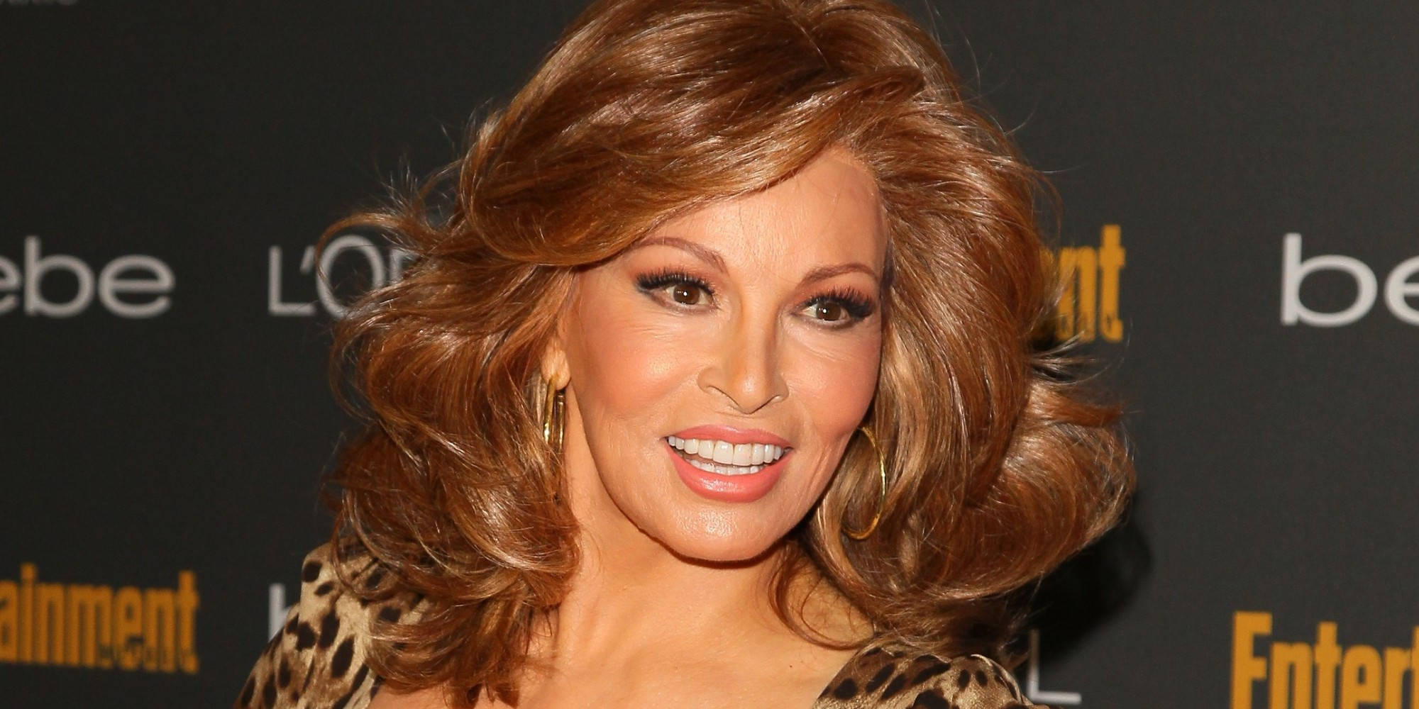 Celebrity 桌布 壁紙 — 一位魅力四射的女性，擁有豐盈的棕色頭髮和大膽的妝容，在紅地毯活動中穿著豹紋上衣，燦爛地微笑。