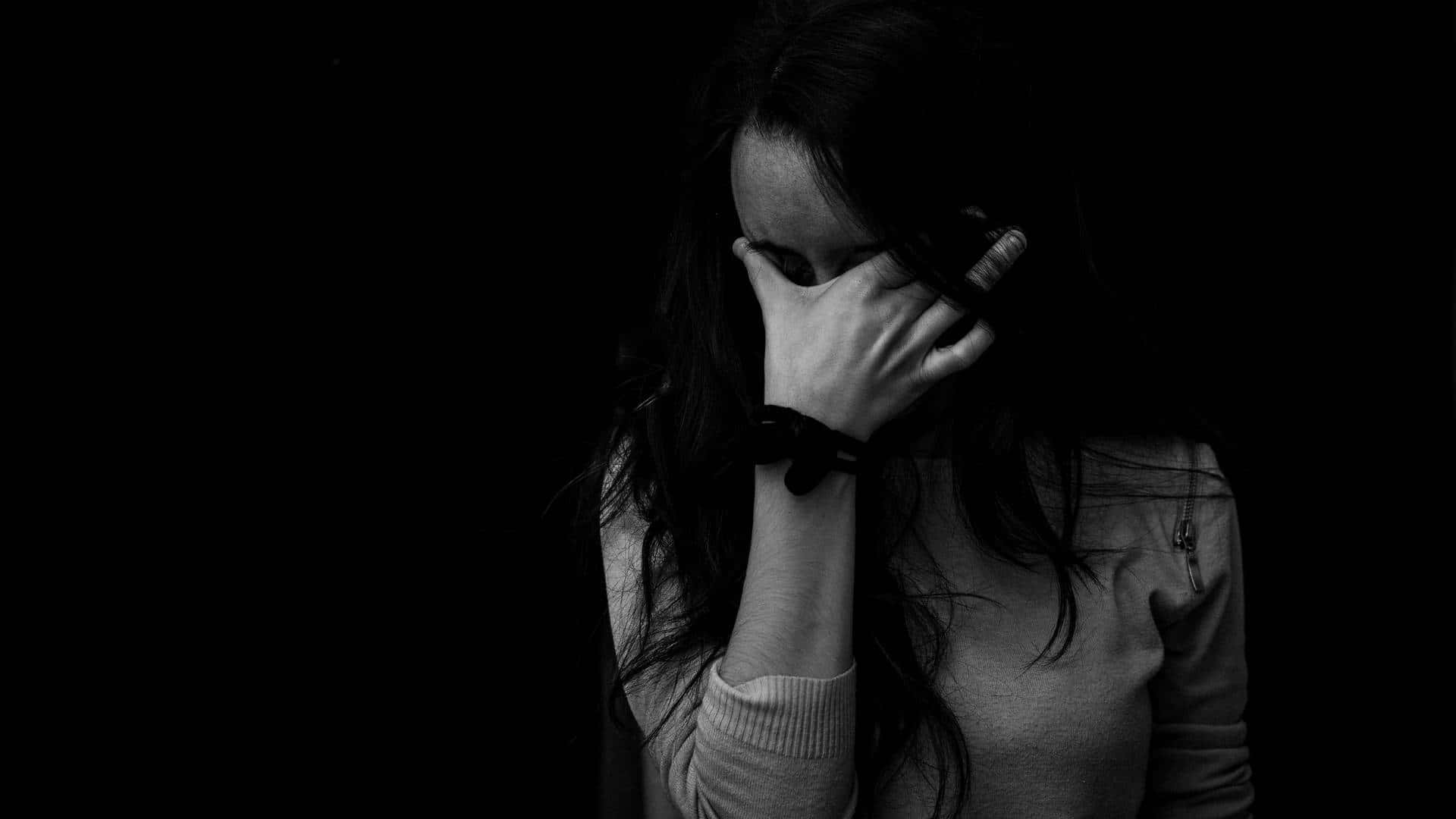 Dark Emotional 桌布 壁紙 — 一位黑白女性在黑暗背景下用手遮住臉。