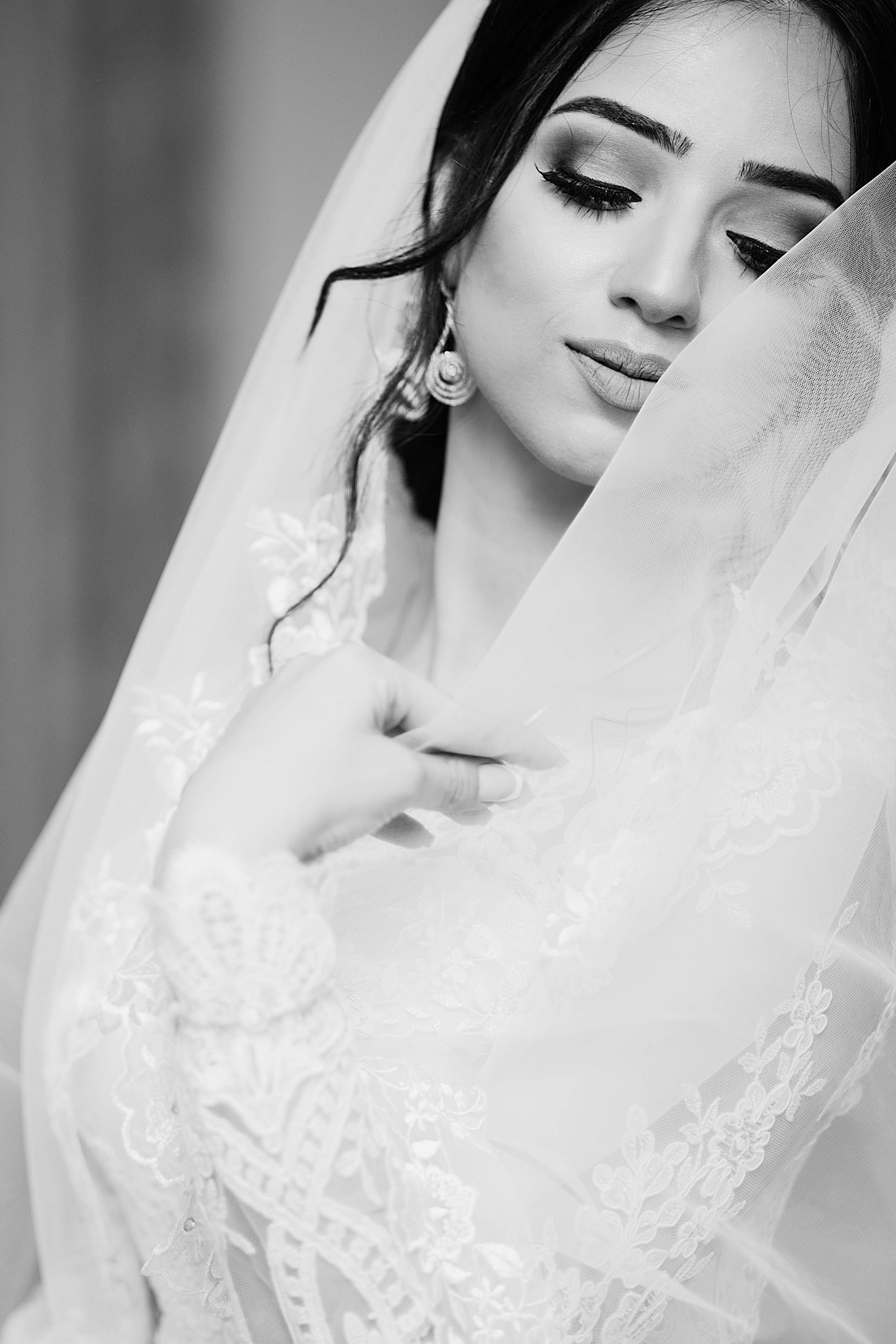 Bridal 桌布 壁紙 — 一位黑白新娘輕輕地將頭紗放在臉上，表情平靜。