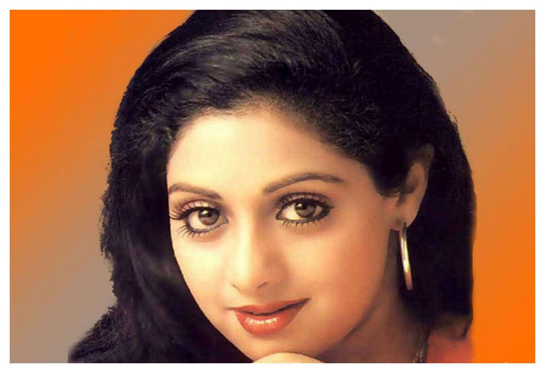 Sridevi 桌布 壁紙 — 一位黑髮、笑容溫暖的女子的特寫肖像，背景為橙色漸層。