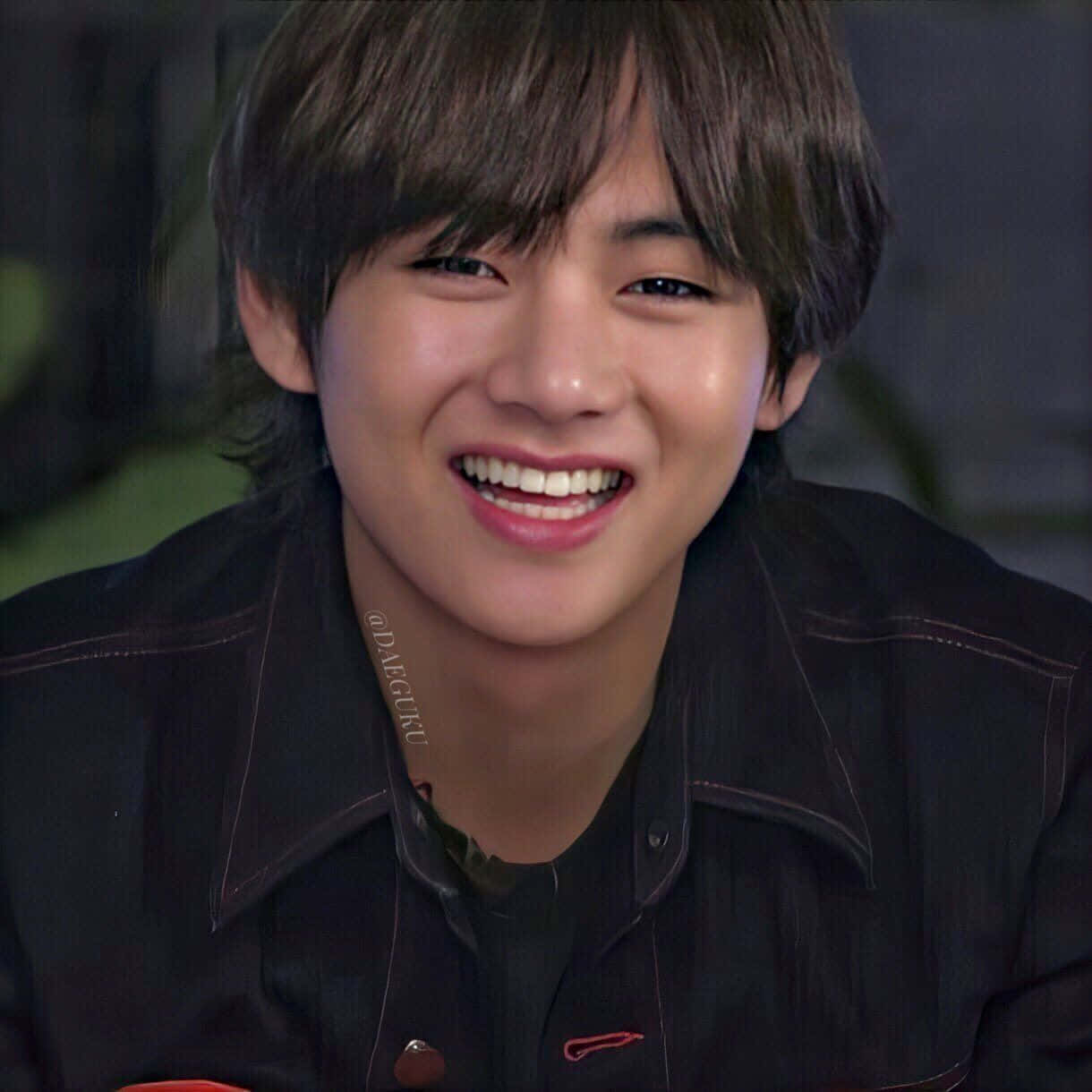 Taehyung Cute 桌布 壁紙 — 一位黑髮、笑容燦爛的年輕男子穿著黑色外套的特寫肖像。