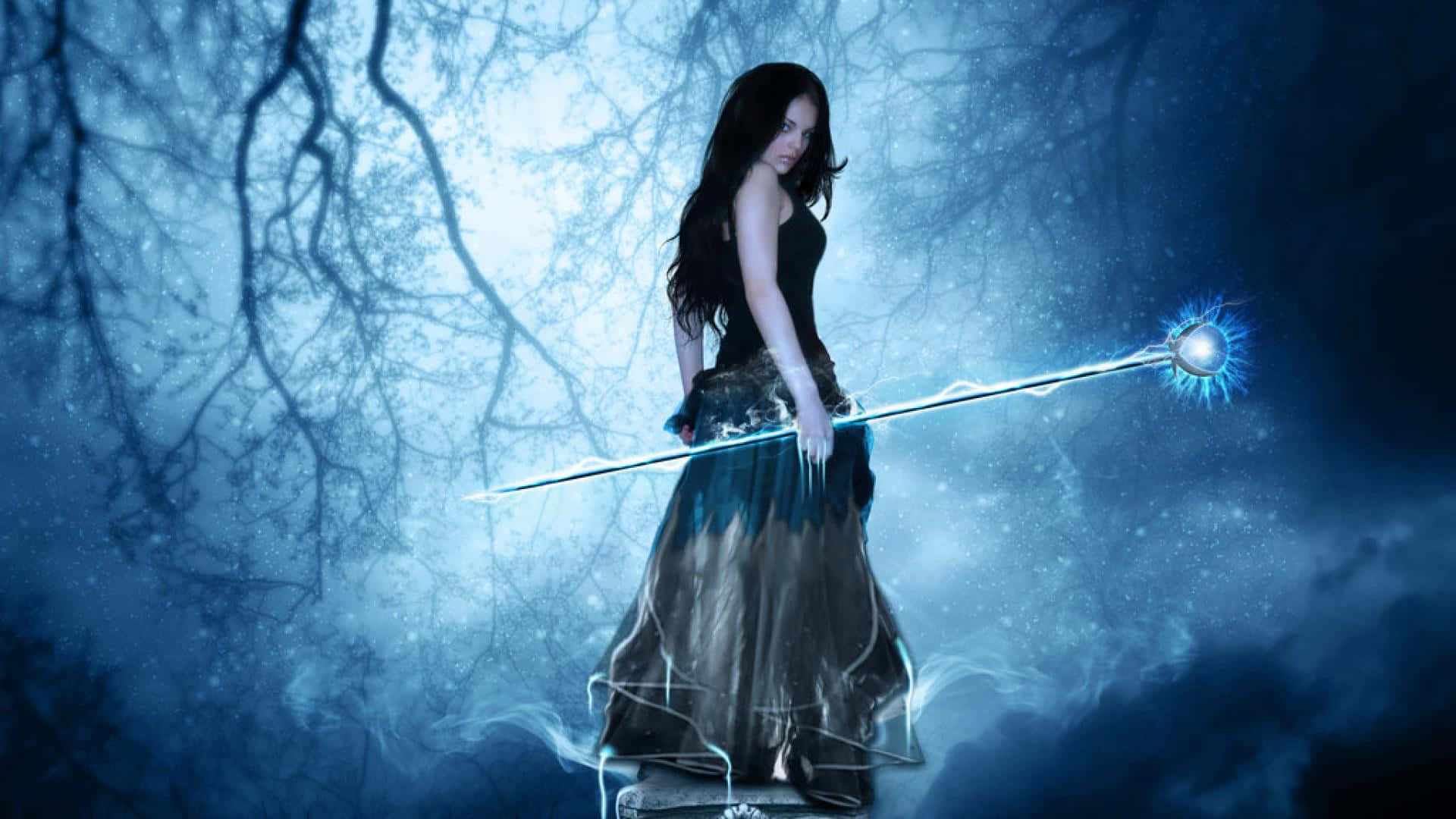 Evil Fairy 桌布 壁紙 — 一位黑髮女子身穿飄逸長裙，站在月光照耀的森林中，手持發光的藍色法杖。