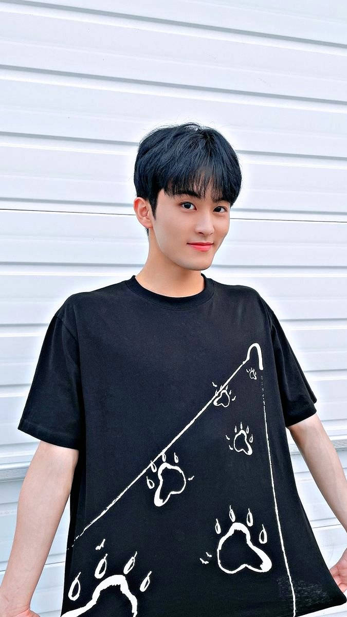 Nct 桌布 壁紙 — 一位黑髮年輕男子微笑著，身穿印有白色爪印和雨滴圖案的黑色T恤，背景是白色波紋牆。