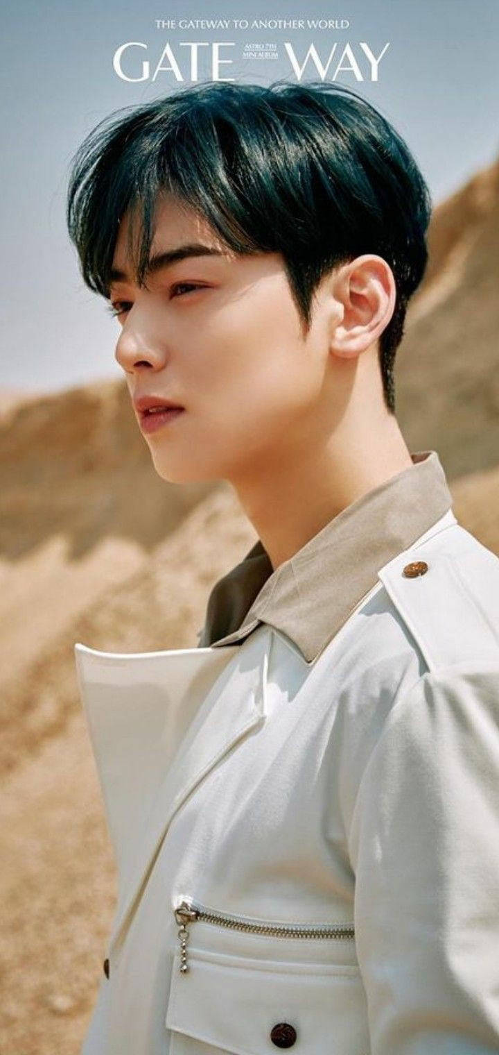 Eunwoo 桌布 壁紙 — 一位黑髮年輕男子身穿白色外套，在陽光明媚的沙漠背景下若有所思地凝視。
