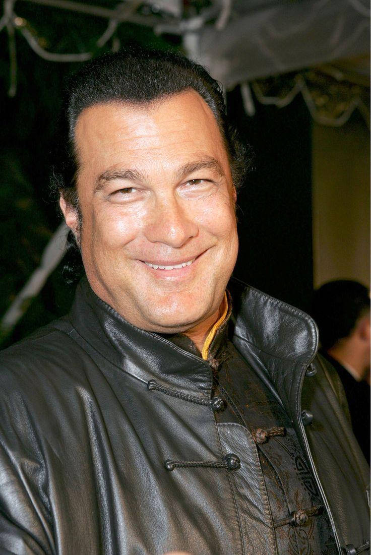 Steven Seagal 桌布 壁紙 — 一位黑髮微笑男士的近距離肖像，身穿帶有傳統盤扣的黑色皮夾克。
