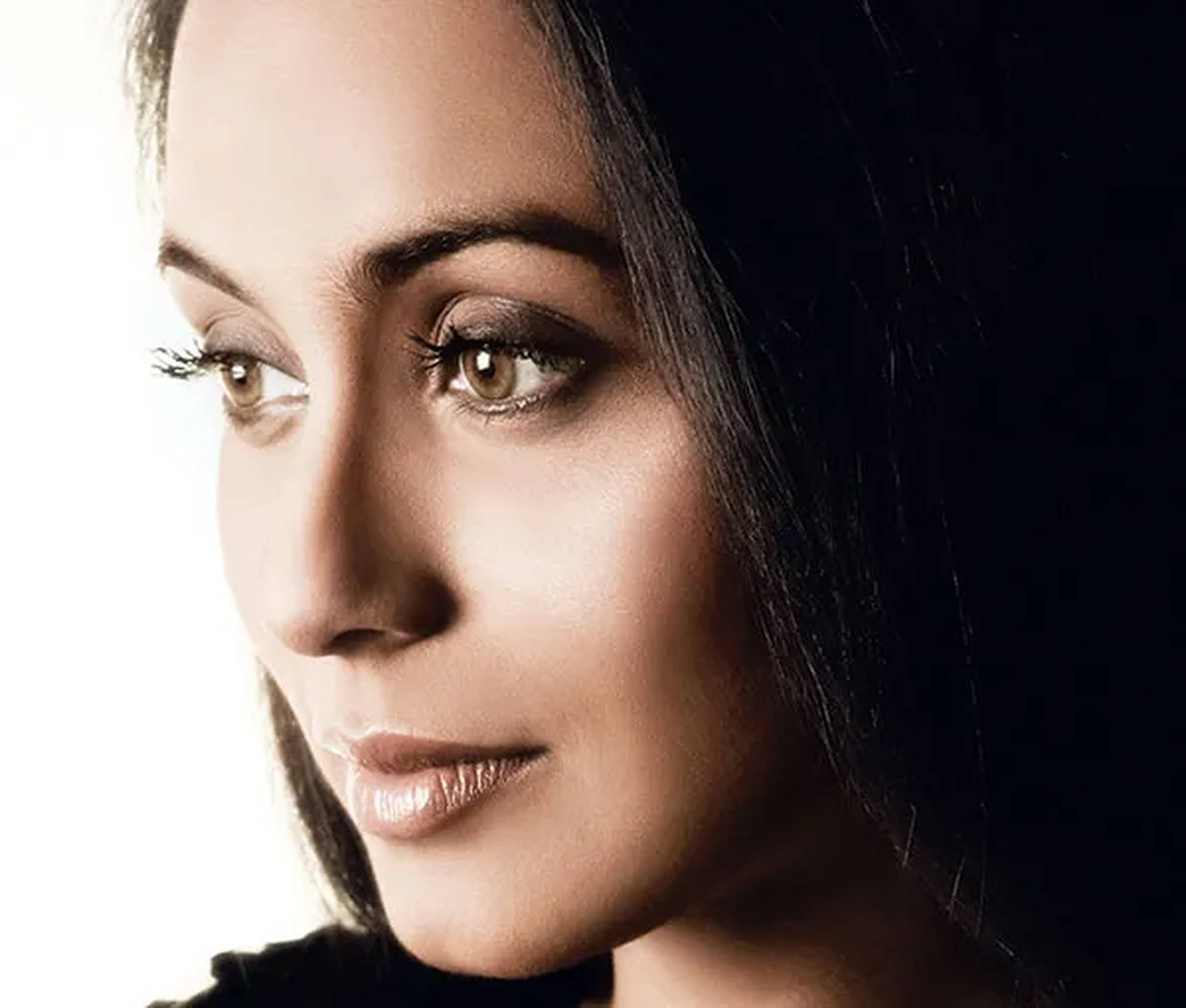 Rani Mukerji 桌布 壁紙 — 一位黑髮暖眸女性的特寫肖像，在純白與黑色背景前若有所思地凝視。
