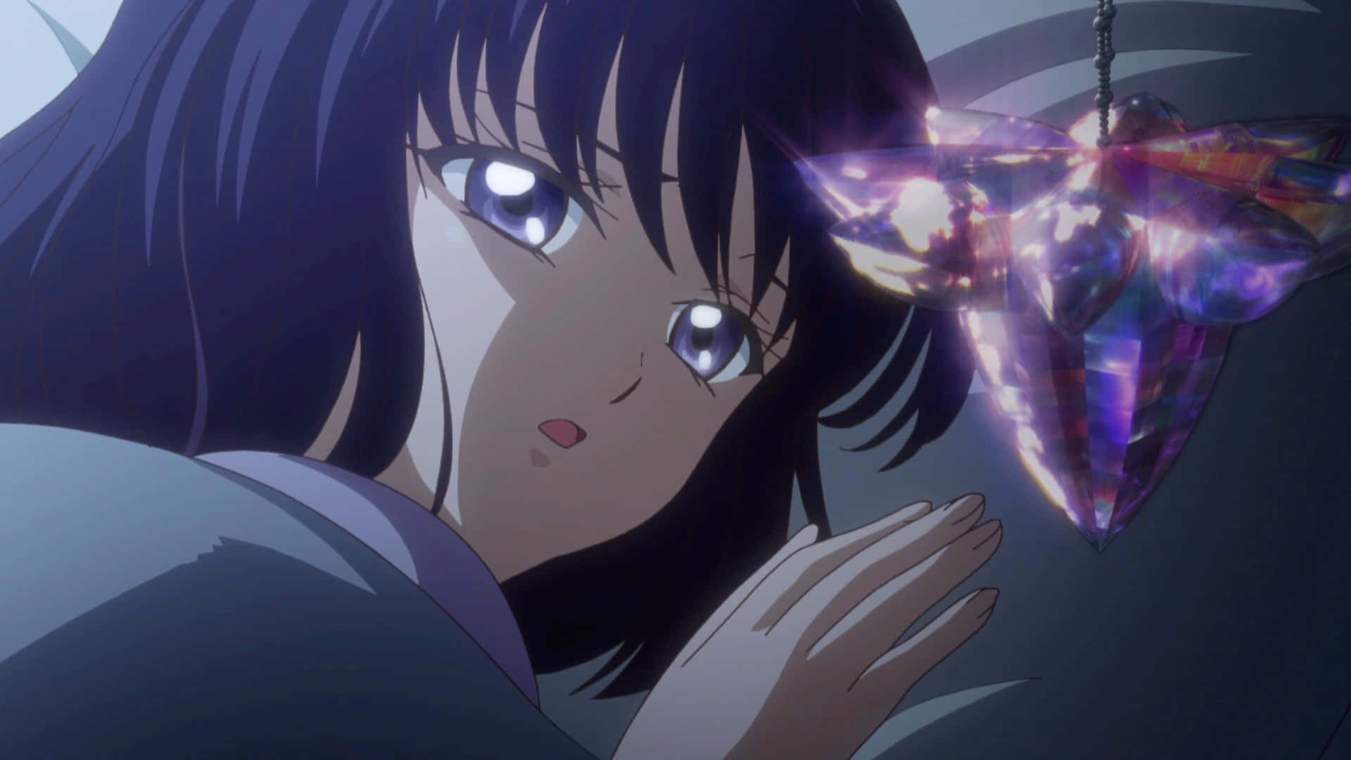 Sailor Saturn 桌布 壁紙 — 一位黑髮的年輕動漫女孩驚奇地凝視著懸掛在她面前、發光的紫色水晶吊墜。