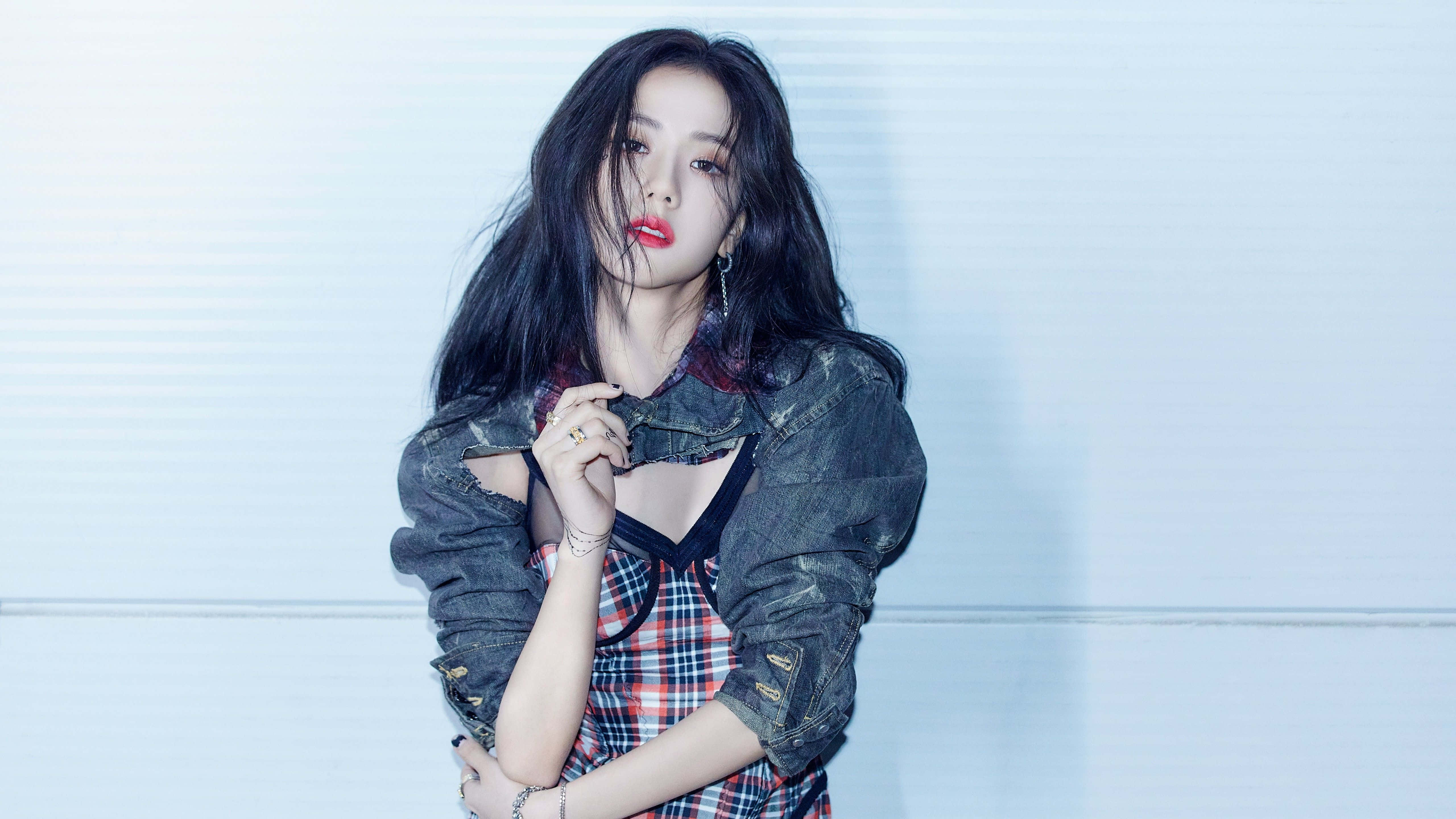 BLACKPINK 桌布 壁紙 — 一位黑髮紅唇的年輕女性，身穿牛仔外套，在淺藍色鑲板牆前自信地擺姿勢。