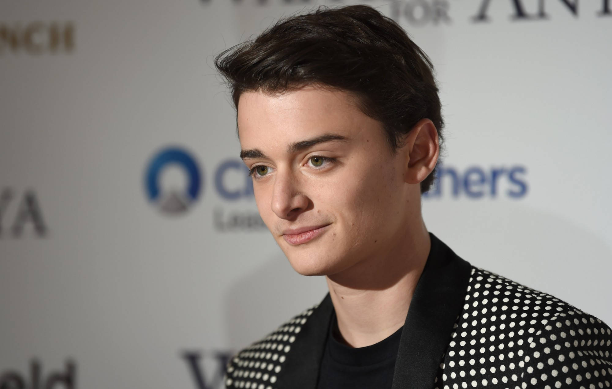 Celebrity 桌布 壁紙 — 一位黑髮綠眼的年輕男士在品牌活動中穿著帶有白色圓點的黑色外套。