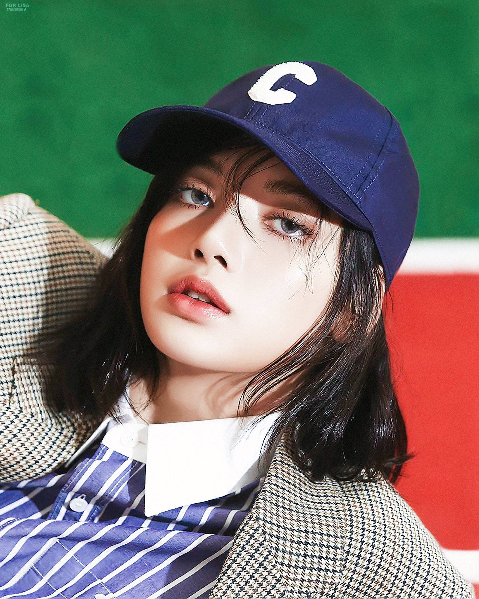 Lalisa 桌布 壁紙 — 一位黑髮藍眼的年輕女性戴著海軍藍帽子，上面有白色「C」，背景是鮮明的綠色和紅色。