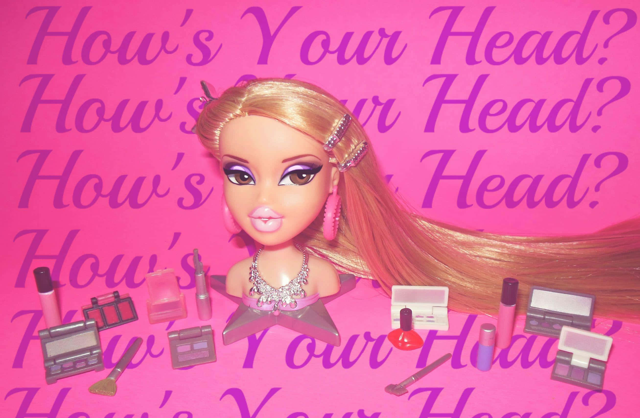 Bratz 桌布 壁紙 — 一個 Bratz 娃娃，擁有金色長髮和閃亮化妝，坐在粉紅色背景上，周圍環繞著化妝品，背景重複著 How's Your Head? 這句話。