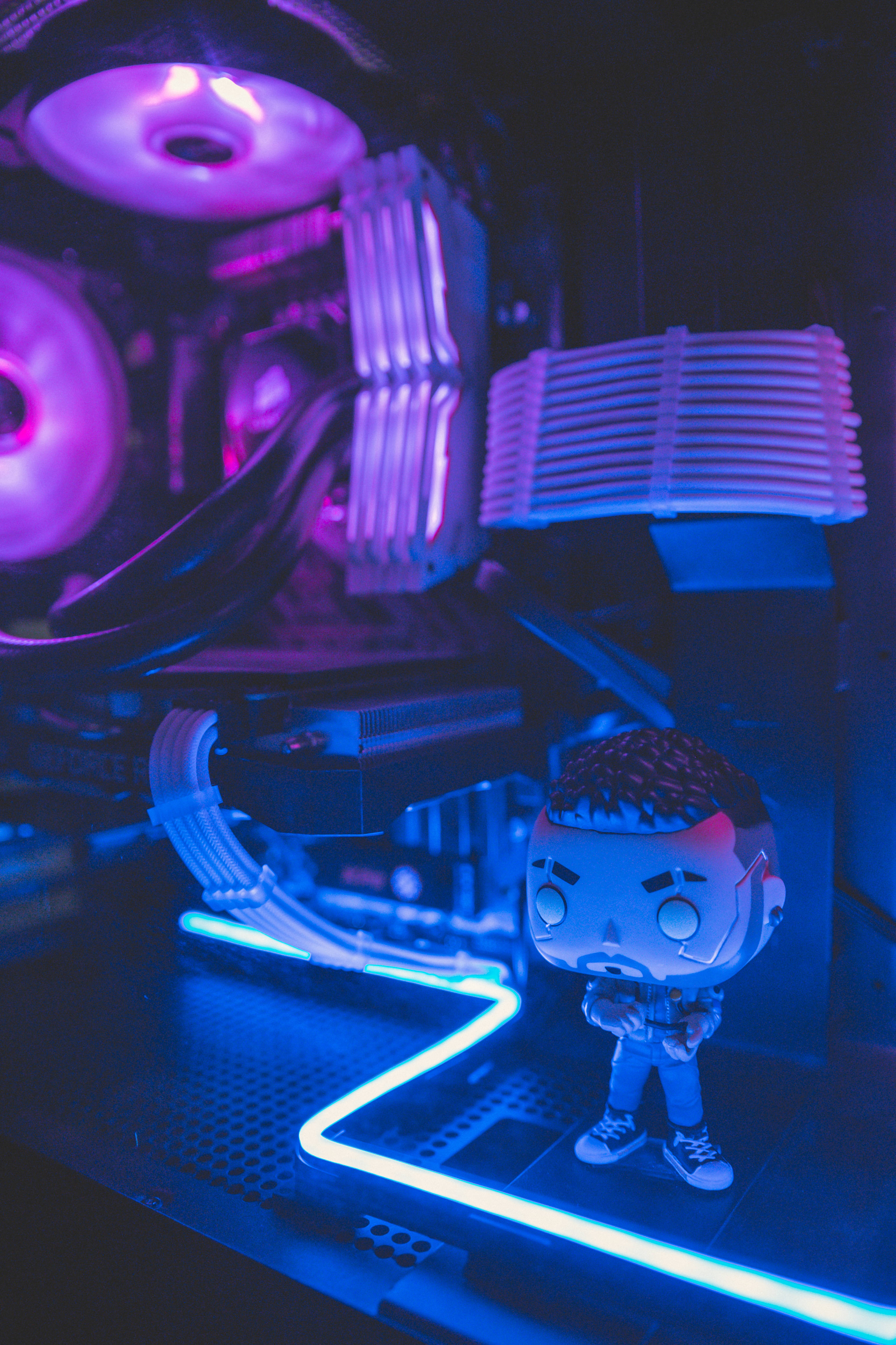 電馭叛客2077 桌布 壁紙 — 一個 Funko Pop 公仔站在發光紫色和藍色的自訂電腦前，帶有霓虹燈管和 RGB 風扇。