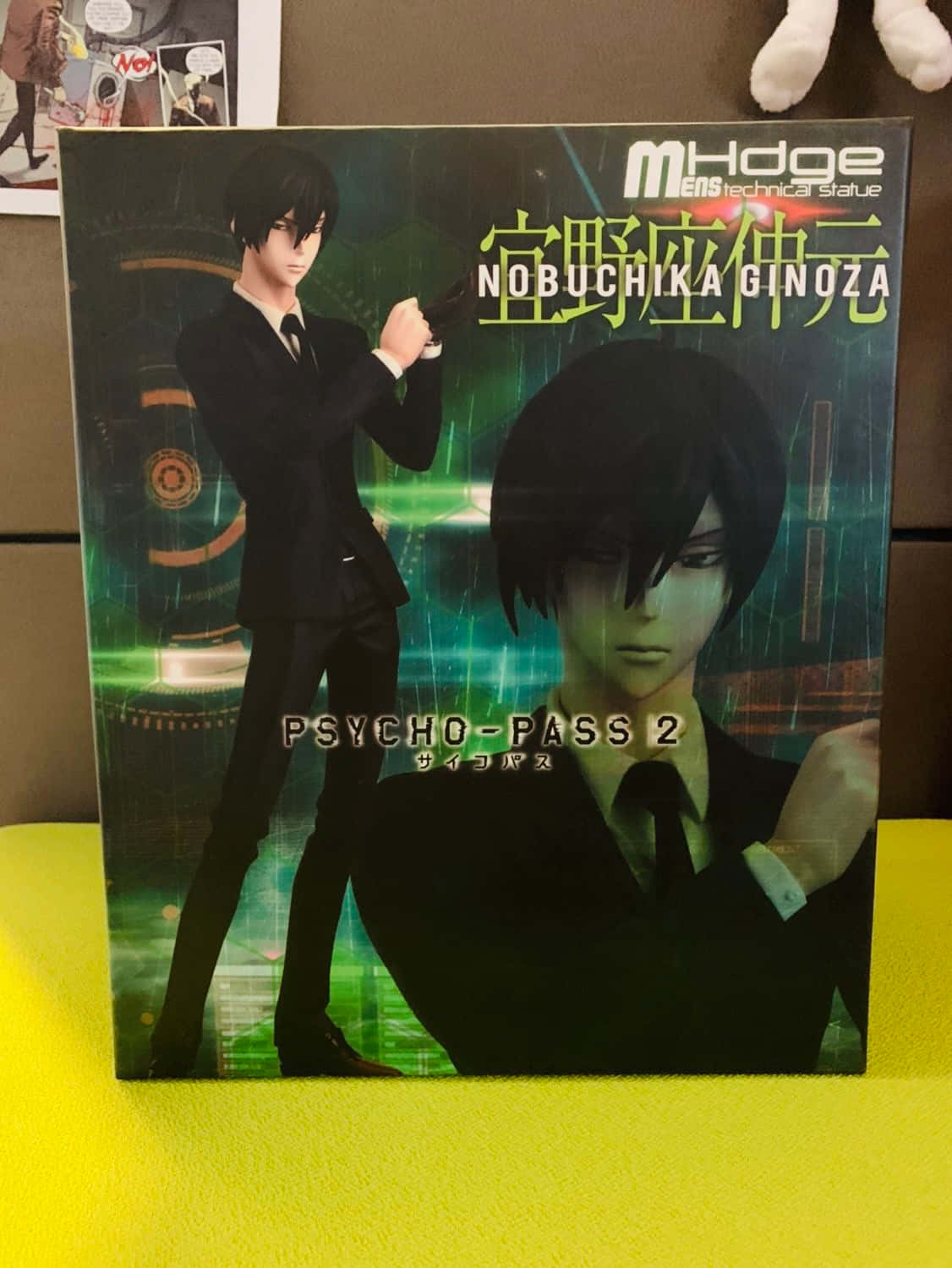 Nobuchika Ginoza 桌布 壁紙 — 一個《PSYCHO-PASS 2》動漫人偶盒， featuring 宜野座伸元身穿黑色西裝，在發光的綠色數位背景前手持槍械。