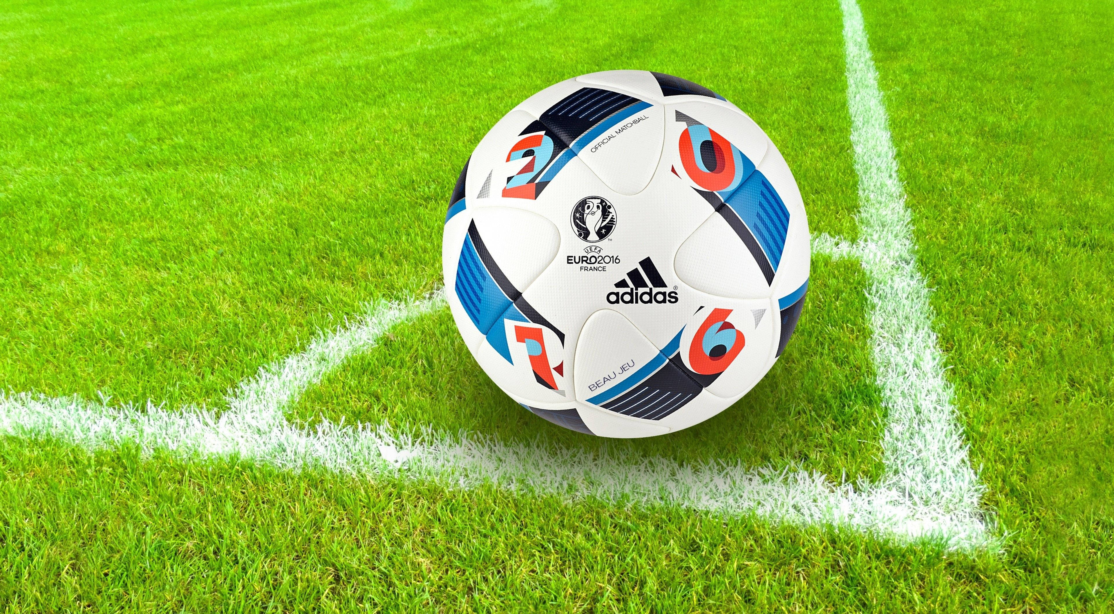 足球 桌布 壁紙 — 一個 UEFA Euro 2016 Adidas 足球精確地放在一個由清晰白線標記的充滿活力的綠色足球場的角落。