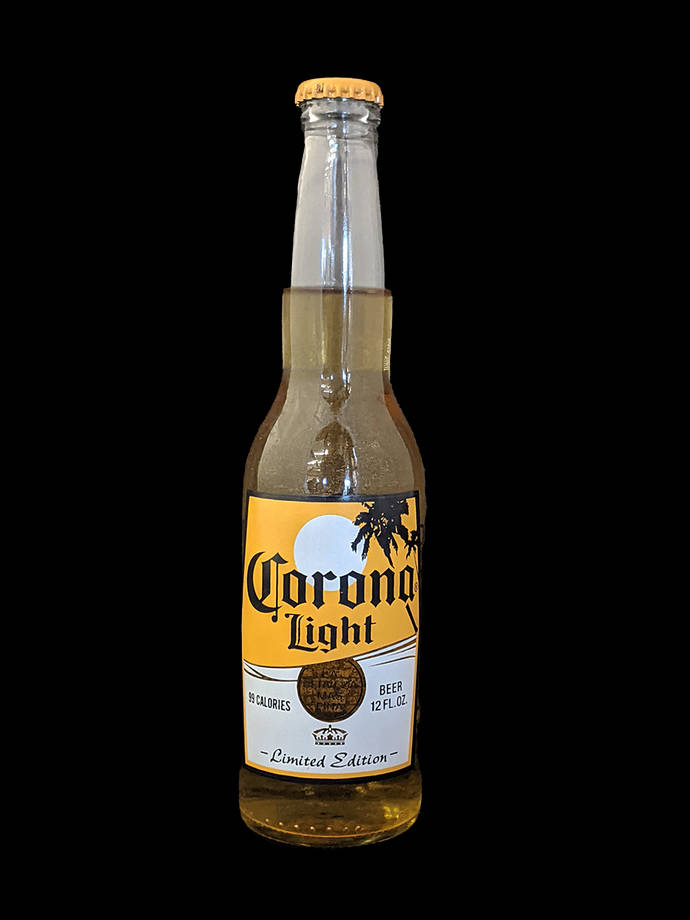 corona 桌布 壁紙 — 一個Corona Light啤酒瓶，帶有黃色標籤和橙色瓶蓋，孤立地立在純黑色背景上。