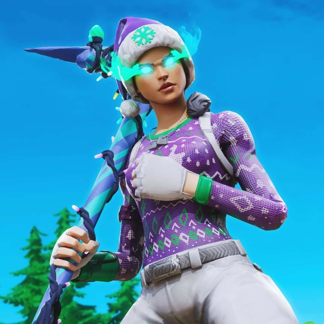 Fortnite 桌布 壁紙 — 一個Fortnite角色穿著紫色節日毛衣和發光綠色護目鏡，在藍天和松樹背景下拿著節日斧頭。