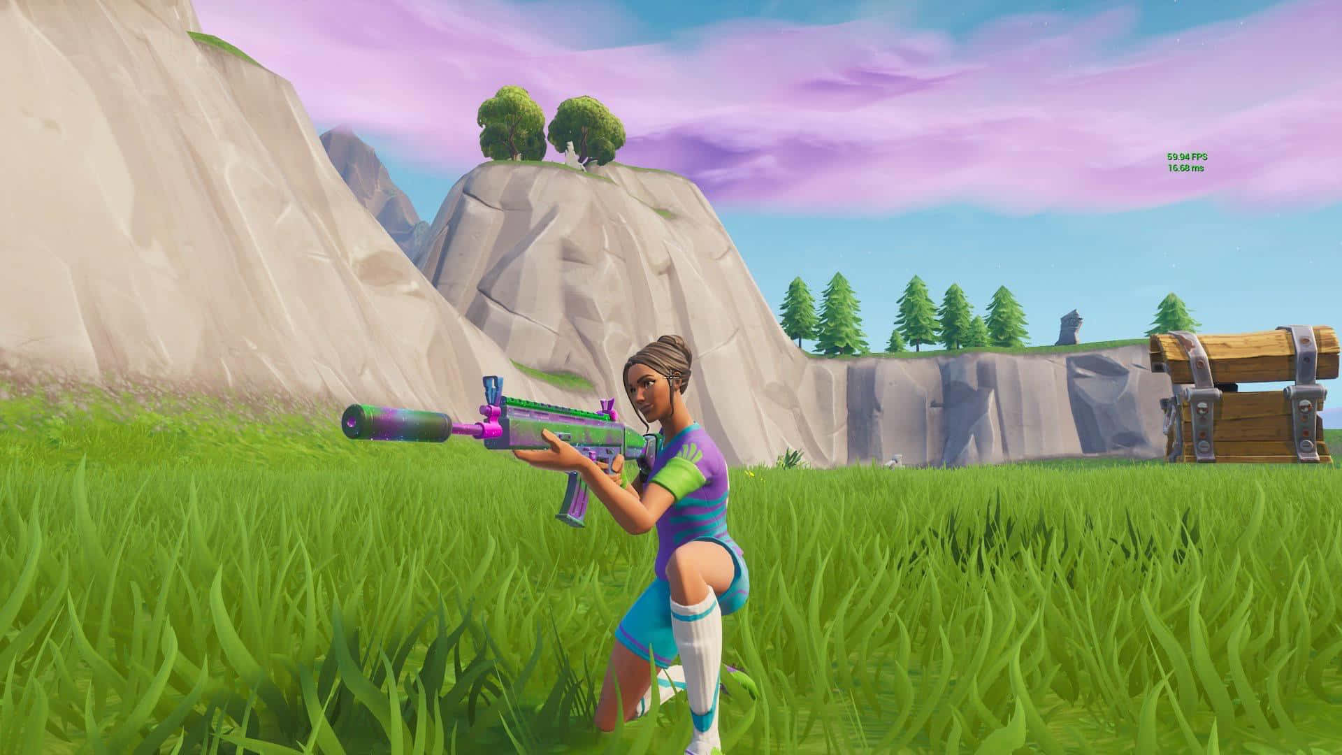 桌布 壁紙 — 一個Fortnite角色蹲在充滿活力的綠色草地上，手持彩色步槍，靠近一個木製寶箱，背景有懸崖和紫色天空。