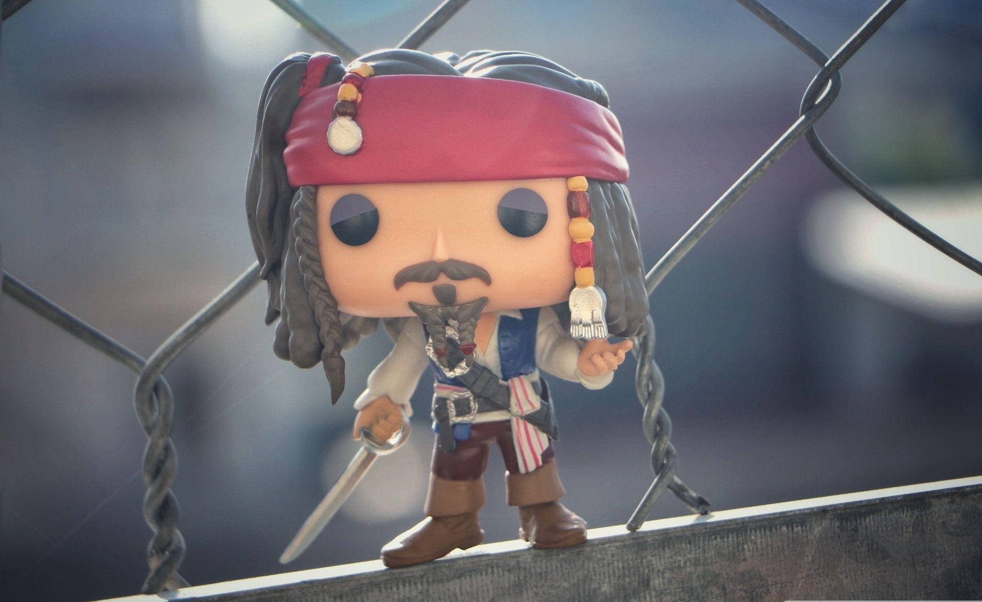 pop 桌布 壁紙 — 一個Jack Sparrow的Funko Pop公仔站在金屬欄杆上，手持劍。