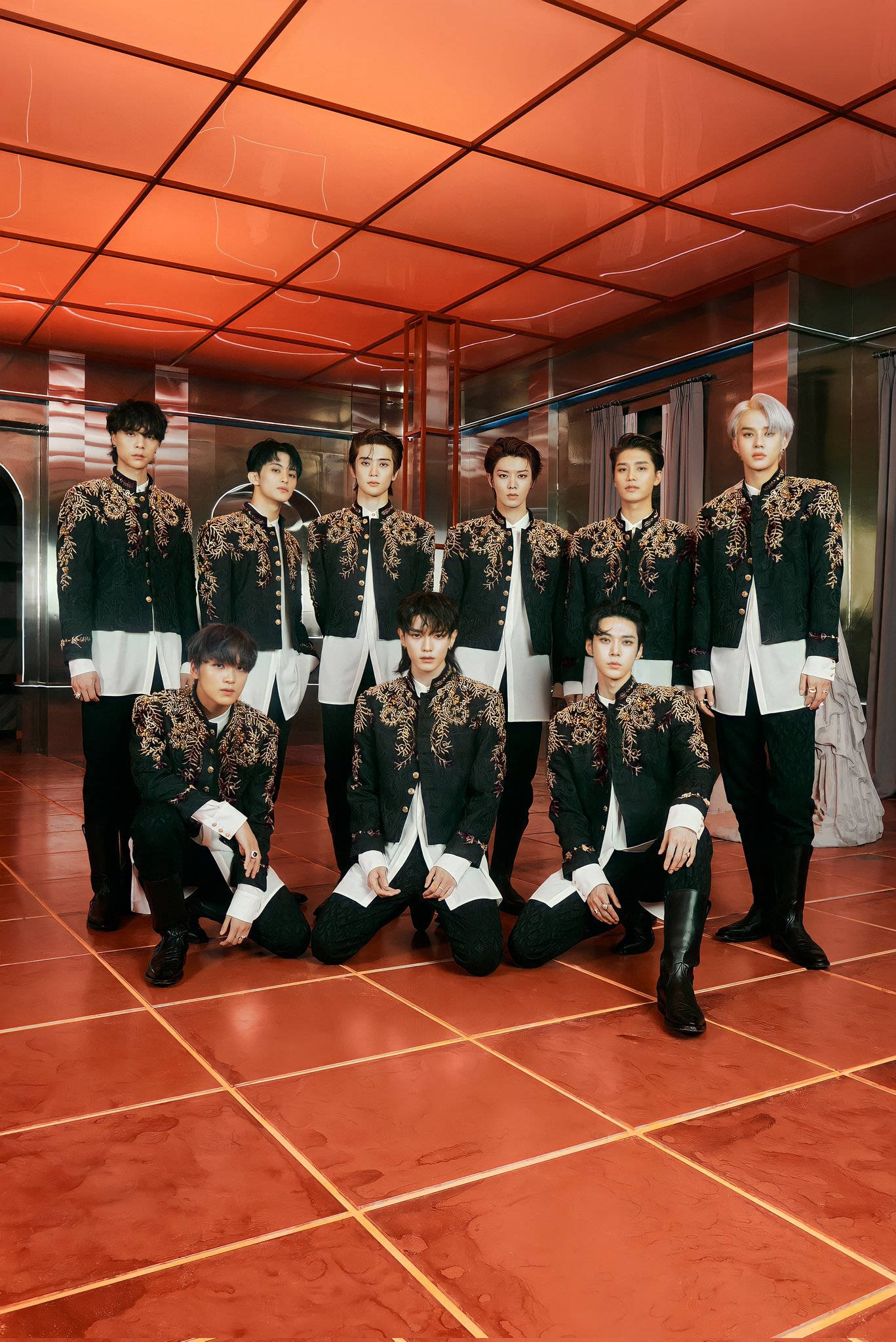 Nct 桌布 壁紙 — 一個K-pop團體在鋪有紅色磁磚、帶有反射表面的房間內，穿著黑白刺繡的搭配服裝擺姿勢。