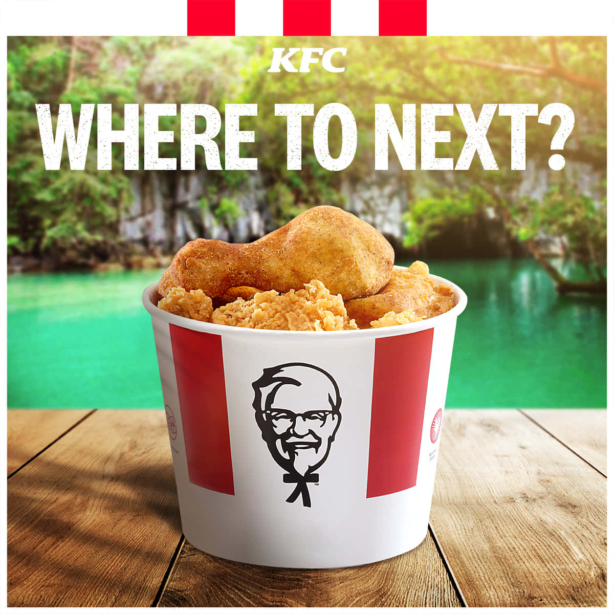 肯德基 桌布 壁紙 — 一個KFC桶裝滿炸雞，放在木桌上，背景是充滿活力的綠色熱帶風光。