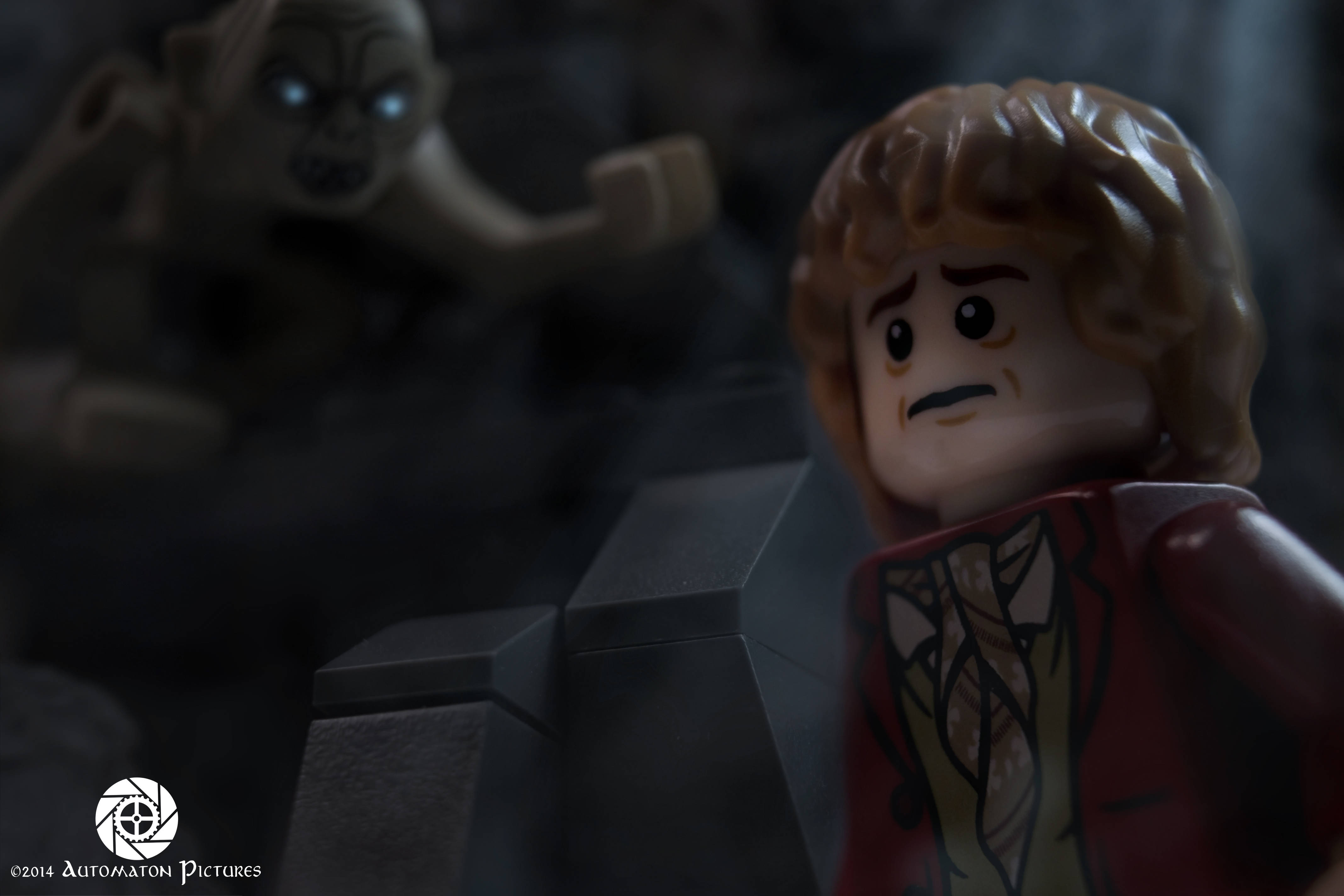 魔戒 桌布 壁紙 — 一個LEGO佛羅多看起來嚇壞了，因為一個兇猛的LEGO哥布林從黑暗洞穴的陰影中撲來。