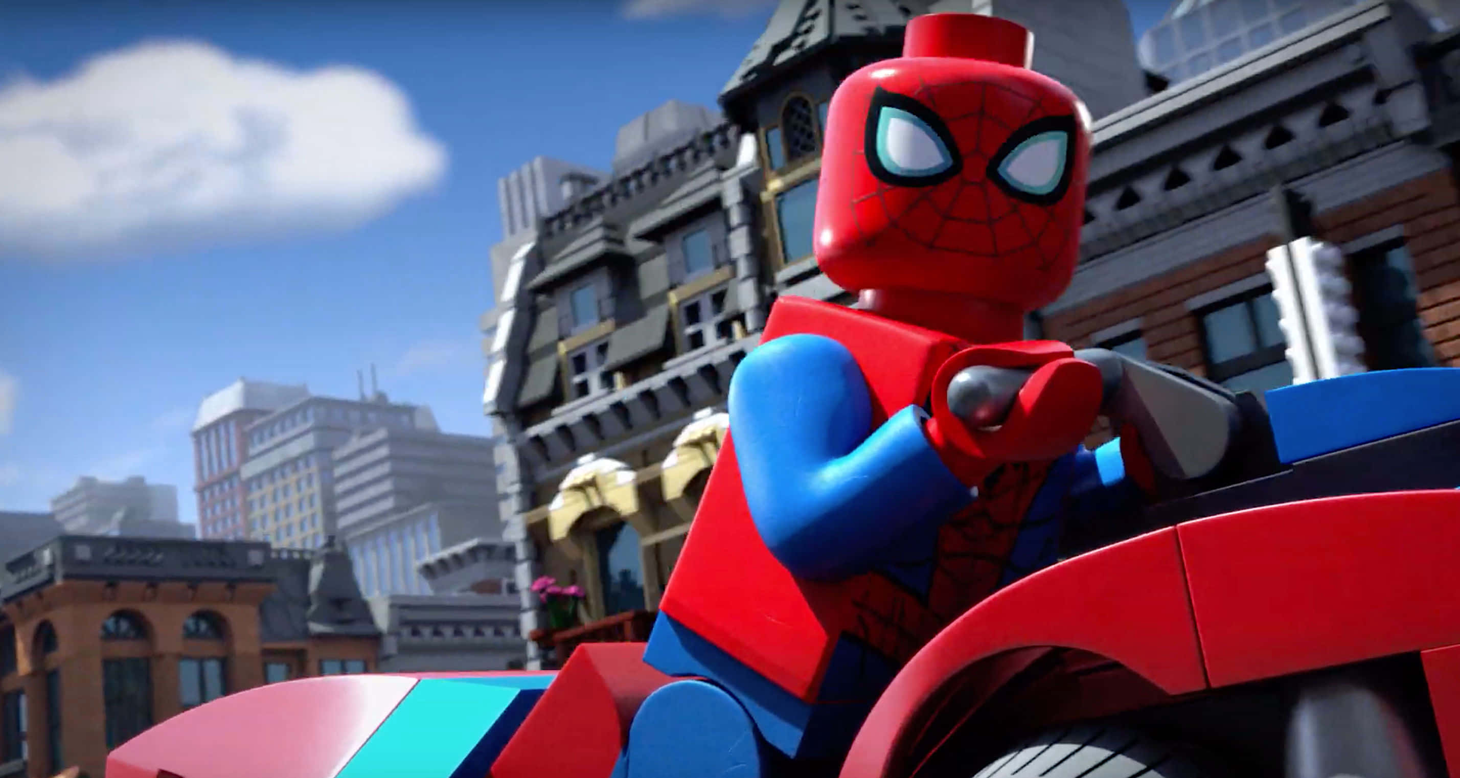 Animated Tv Show 桌布 壁紙 — 一個LEGO蜘蛛人公仔在晴朗的藍天白雲下，騎著紅色摩托車穿梭在細節豐富的城市景觀中。