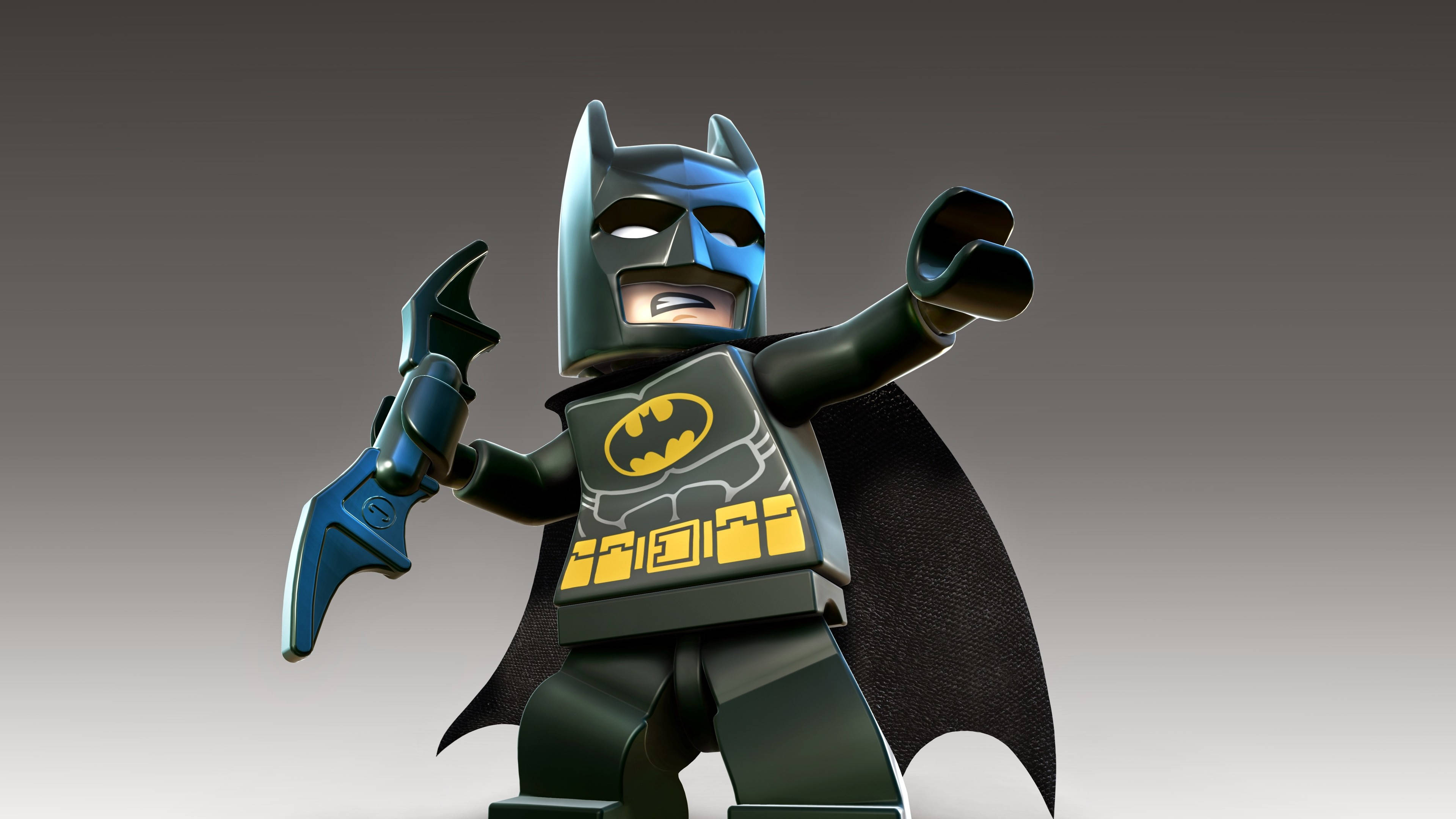 Animated 桌布 壁紙 — 一個LEGO蝙蝠俠迷你人偶英雄般地站立，披風飄揚，手持蝙蝠鏢，背景為漸變灰色。