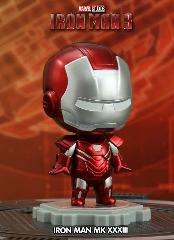 Iron Man Bobbleheads 桌布 壁紙 — 一個Q版風格的鋼鐵人MK XXXIII人偶站在齒輪形底座上，背景為紅色科技主題。