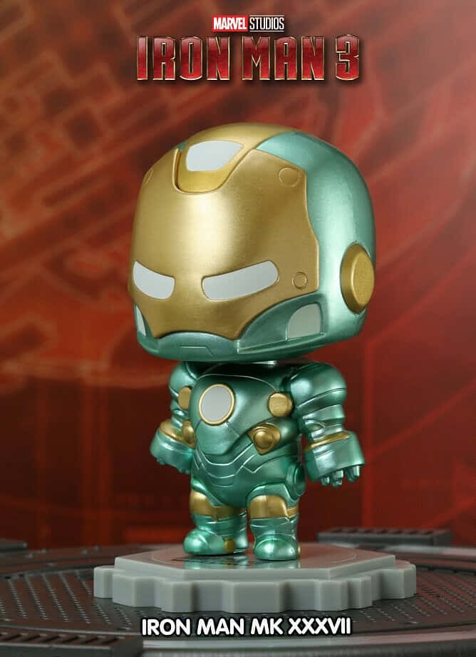 Iron Man Bobbleheads 桌布 壁紙 — 一個Q版風格的鋼鐵人MK XXXVII人偶站在灰色底座上，背景為帶有Marvel Studios品牌的紅色紋理背景。