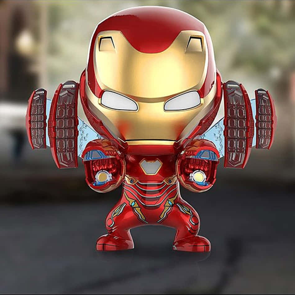 Iron Man Bobbleheads 桌布 壁紙 — 一個Q版風格的鋼鐵人人偶，身穿紅色和金色裝甲，帶有發光的斥力炮和半透明翅膀，背景模糊。