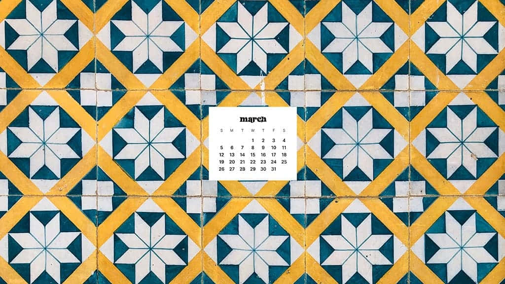 March Desktop 桌布 壁紙 — 一個三月日曆放在充滿活力的黃、藍、白幾何瓷磚牆上，帶有星爆圖案。