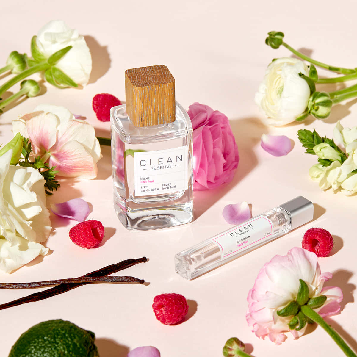 Floral Fragrance 桌布 壁紙 — 一個乾淨的香水瓶，帶有木蓋，周圍環繞著粉紅色和白色的花朵、覆盆子、香草豆和萊姆，背景為柔和的粉紅色。