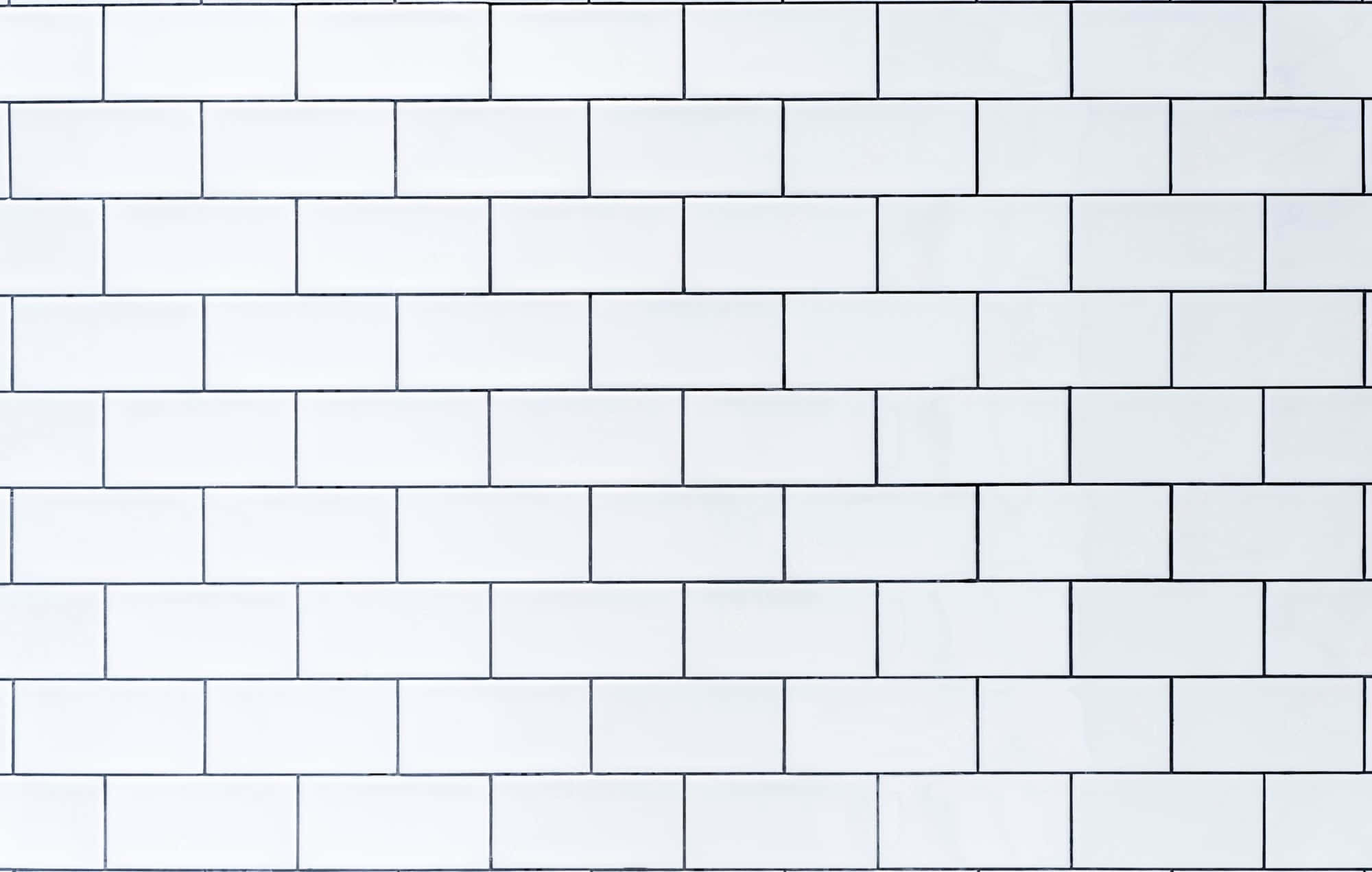 Tile 桌布 壁紙 — 一個乾淨簡約的白色地鐵磚牆，帶有細黑色填縫線，採用經典的工字鋪法。