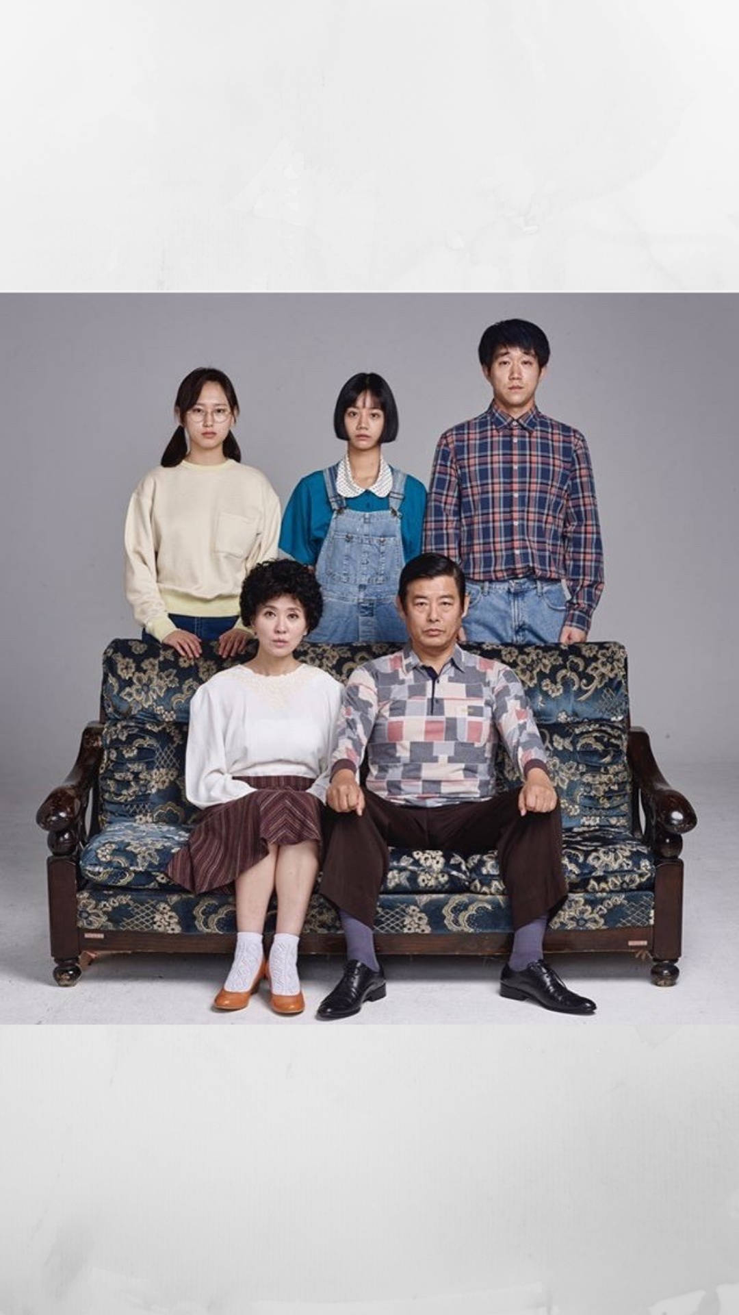 Reply 1988 桌布 壁紙 — 一個五口之家在純灰色工作室背景前，在一張華麗的復古沙發上正式擺姿勢。