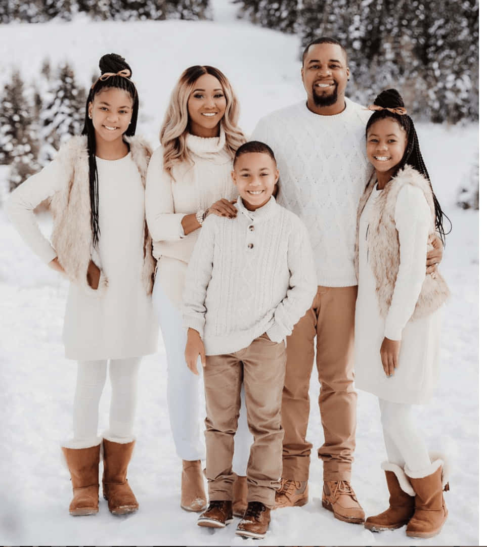Christmas Family 桌布 壁紙 — 一個五口之家在雪地冬季風景中微笑合照，穿著協調的白色和米色冬季服裝。