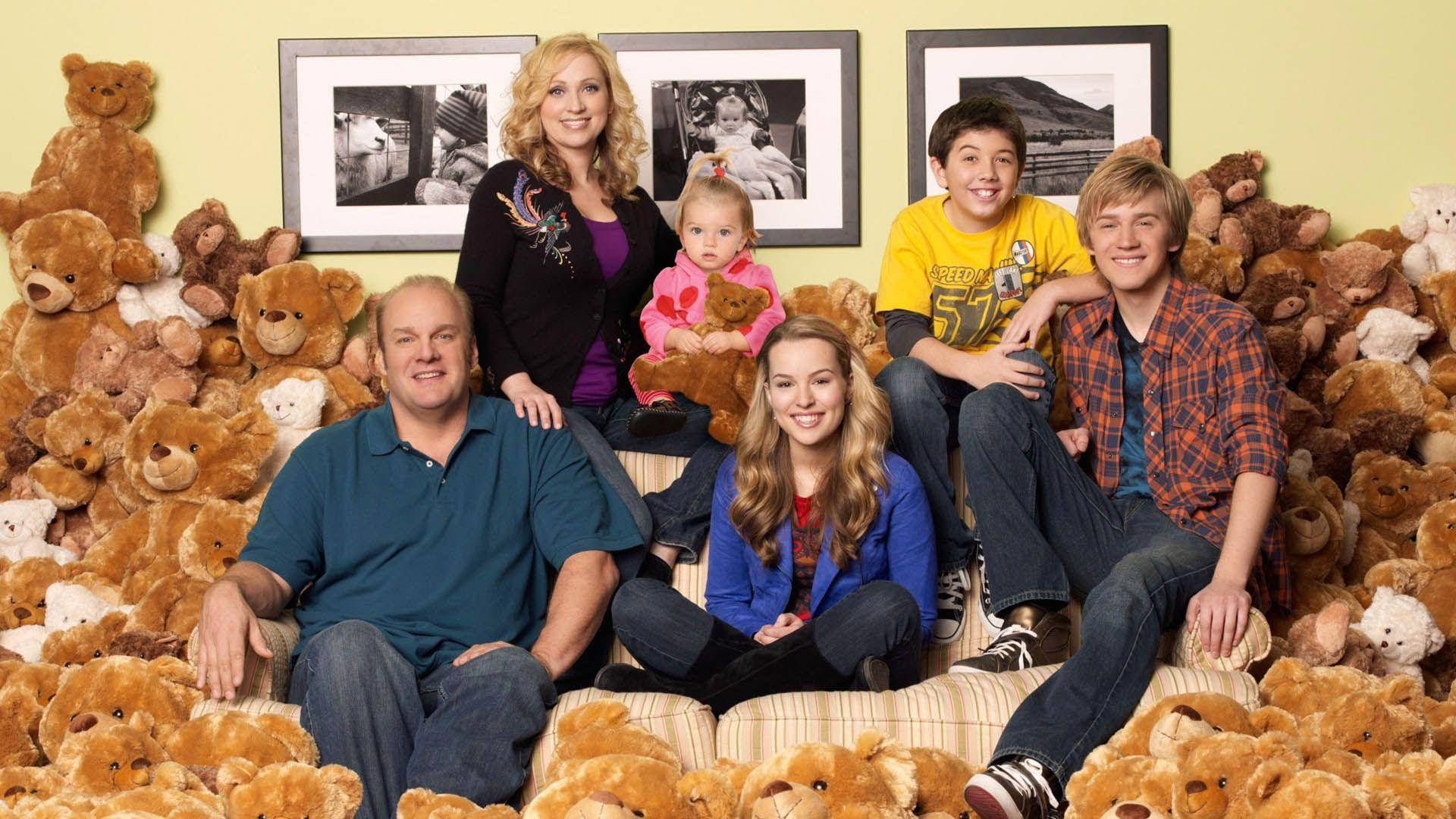 Good Luck Charlie 桌布 壁紙 — 一個五口之家坐在沙發上，被數百隻棕色泰迪熊完全包圍，露出燦爛的笑容。