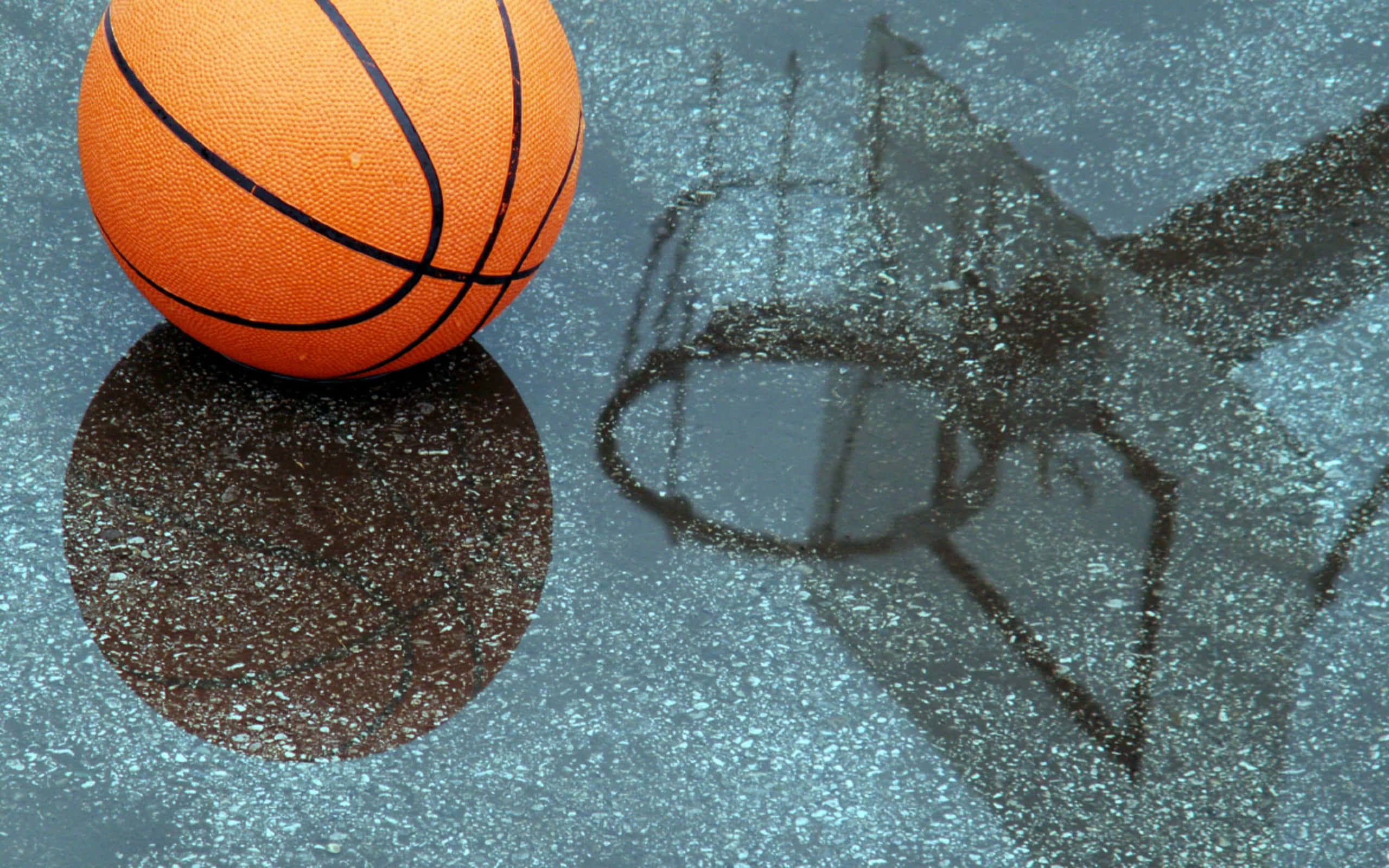 Basketball Court 桌布 壁紙 — 一個亮橙色的籃球放在濕漉漉的路面上，附近有扭曲的籃框倒影。