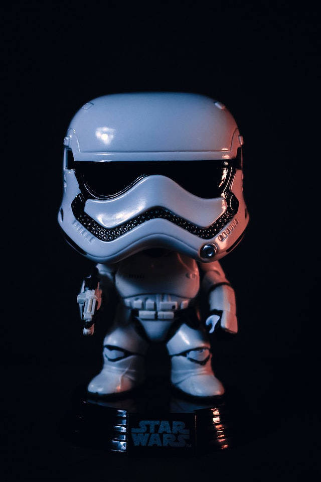 星際大戰 iPhone 桌布 壁紙 — 一個亮白色風暴兵Funko Pop！人偶在黑色背景前發光，帶有Star Wars底座。