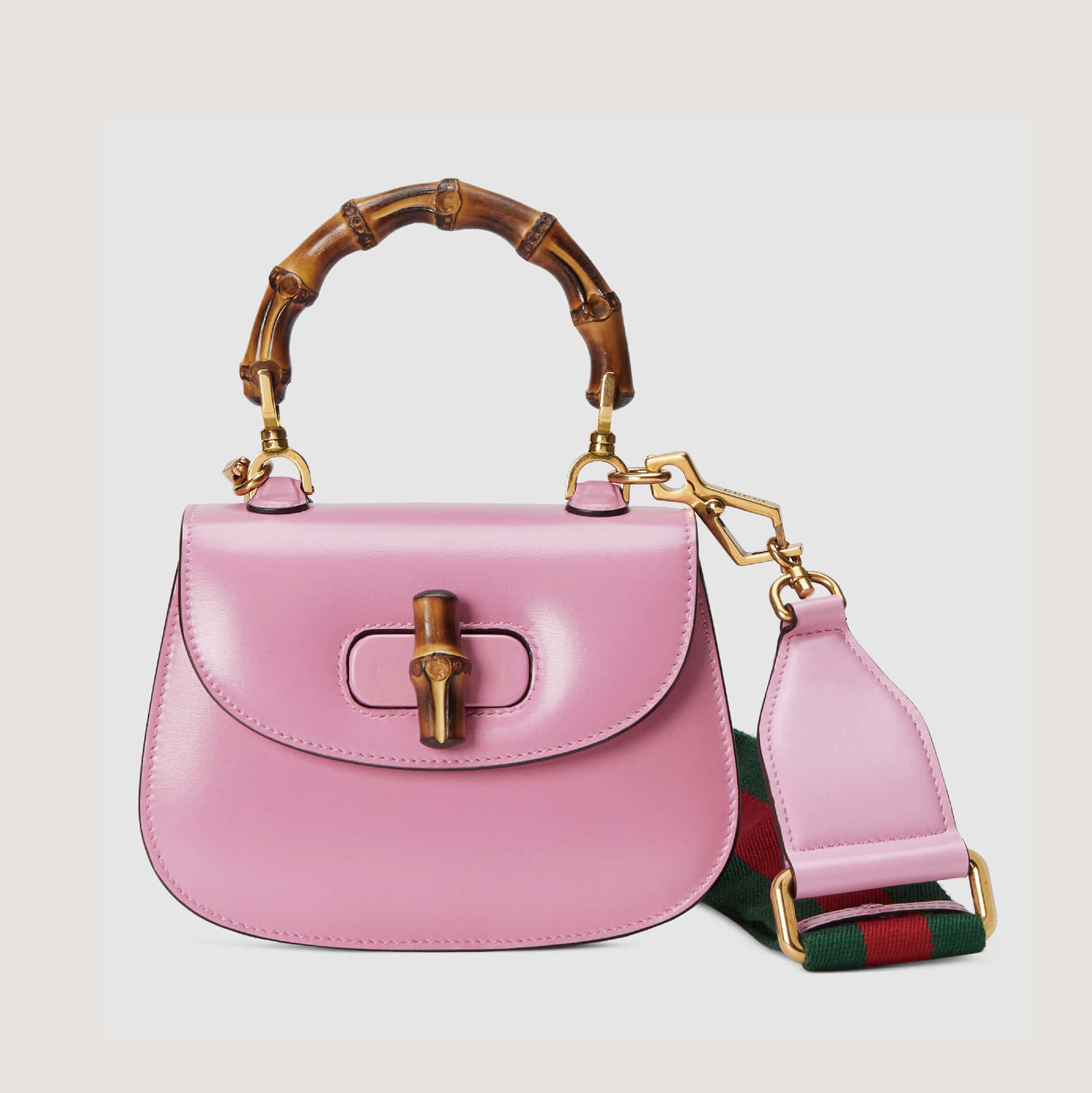 Gucci 桌布 壁紙 — 一個亮面粉紅色皮革手提包，配有標誌性竹手柄和金色金屬配件，背景為中性色。