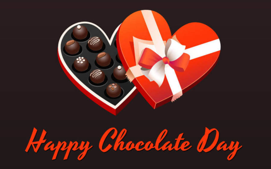 Chocolate Day 桌布 壁紙 — 一個亮面紅色心形巧克力盒，配有白色絲帶，內有各式巧克力，背景深色，並有「Happy Chocolate Day」文字。