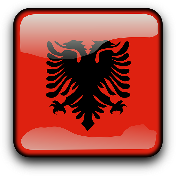 Albania 桌布 壁紙 — 一個亮面紅色方形按鈕，中央有黑色雙頭鷹標誌，圓角設計，金屬邊框。