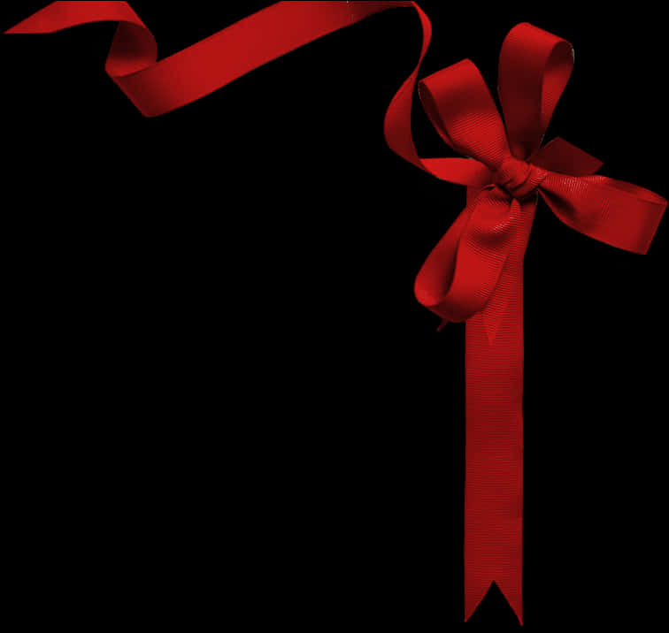 Ribbon Banner 桌布 壁紙 — 一個亮面紅色絲帶蝴蝶結，帶有飄逸的尾部，襯在純黑背景上。