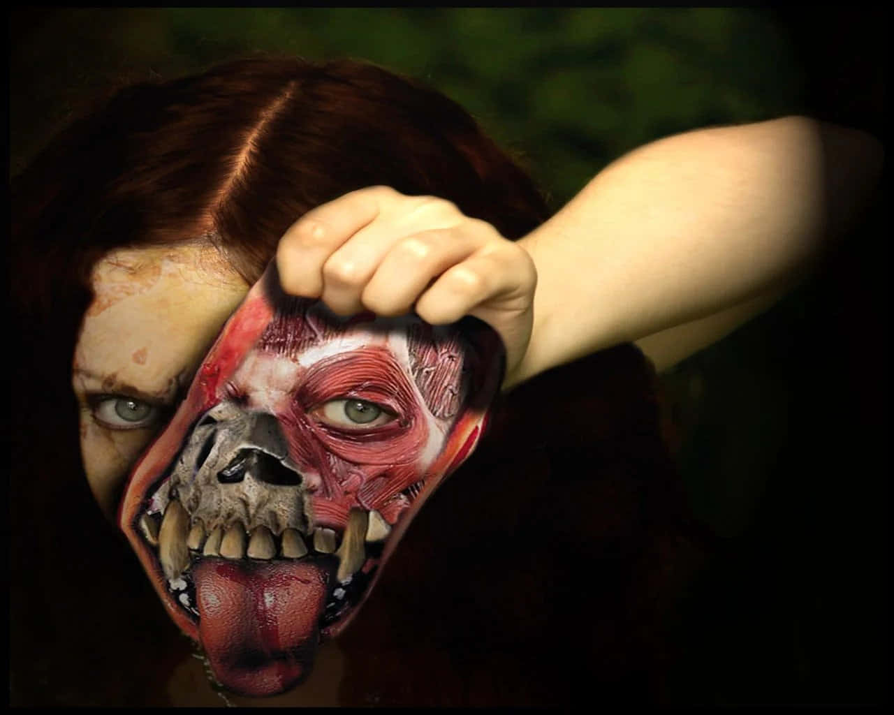Scary Face 桌布 壁紙 — 一個人剝開自己的肉，露出下面一個怪誕的解剖學面孔，在黑暗、令人不安的特寫中。